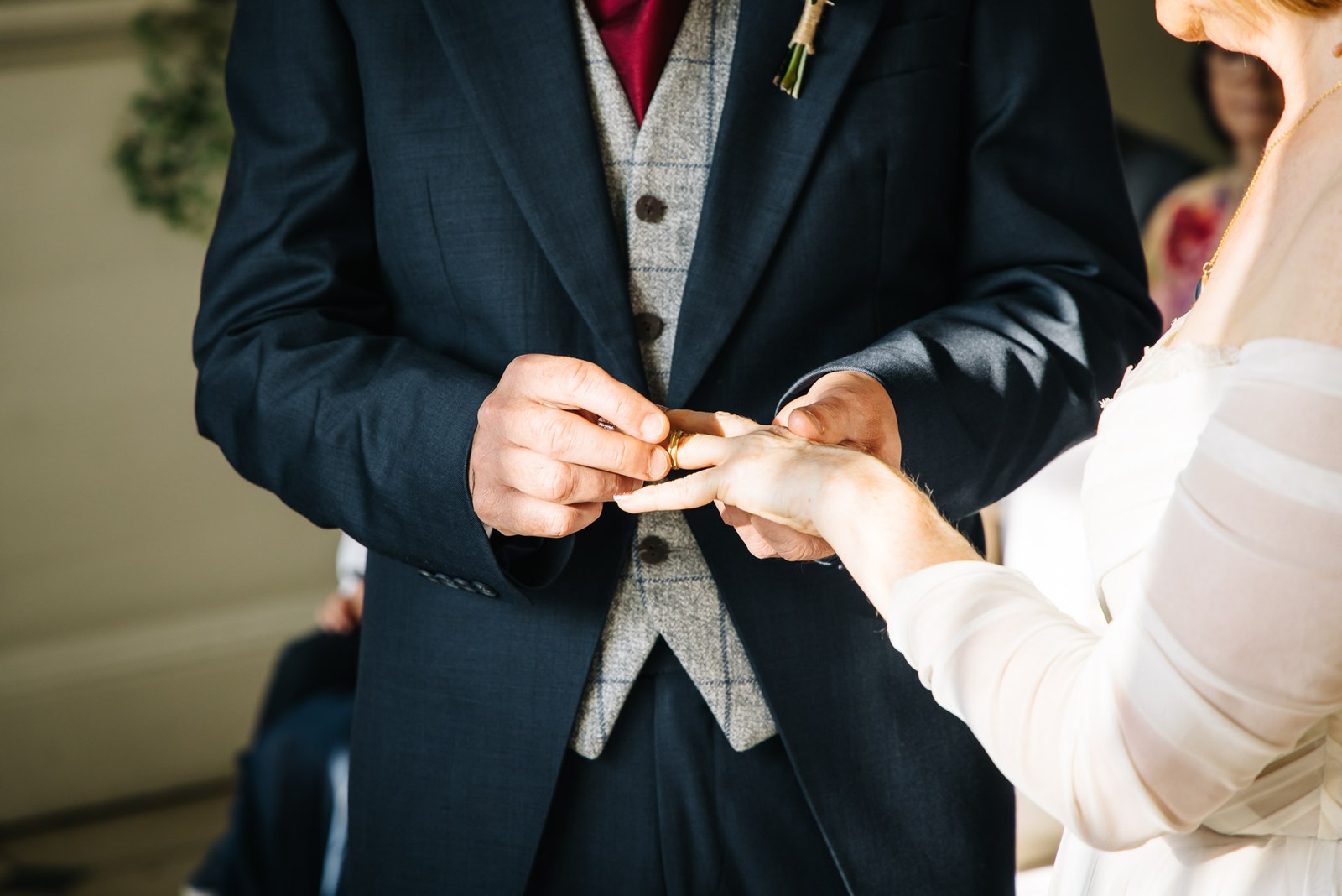Close-up of the groom sliding the wedding ring onto the bride's finger