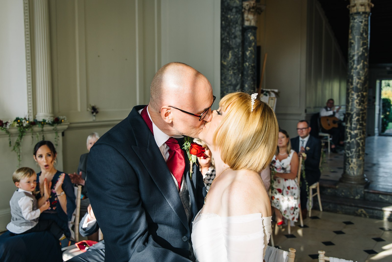 The newlyweds share their first kiss as guests watch from their seats