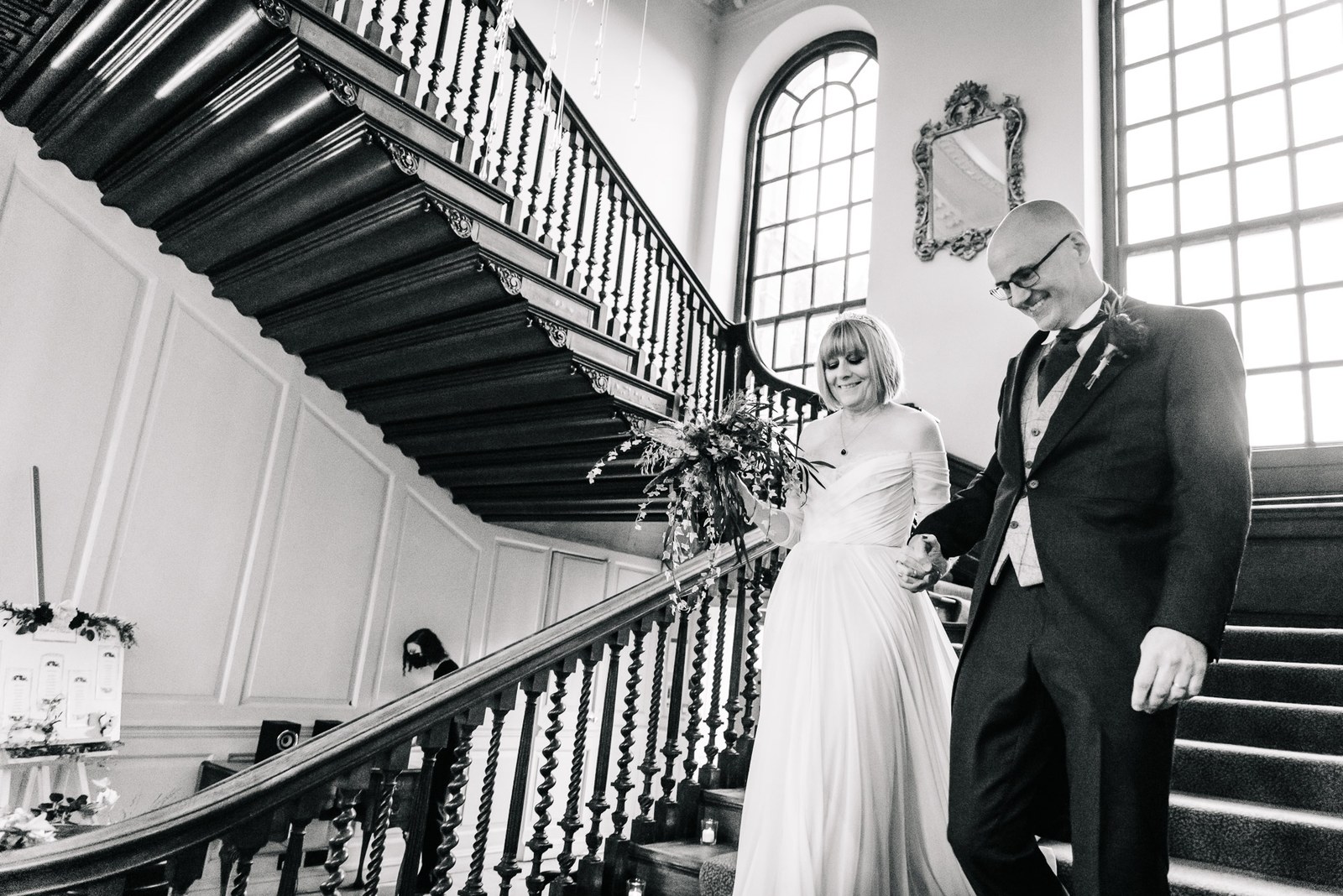 Black-and-white portrait of the couple on Chicheley Hall's grand staircase