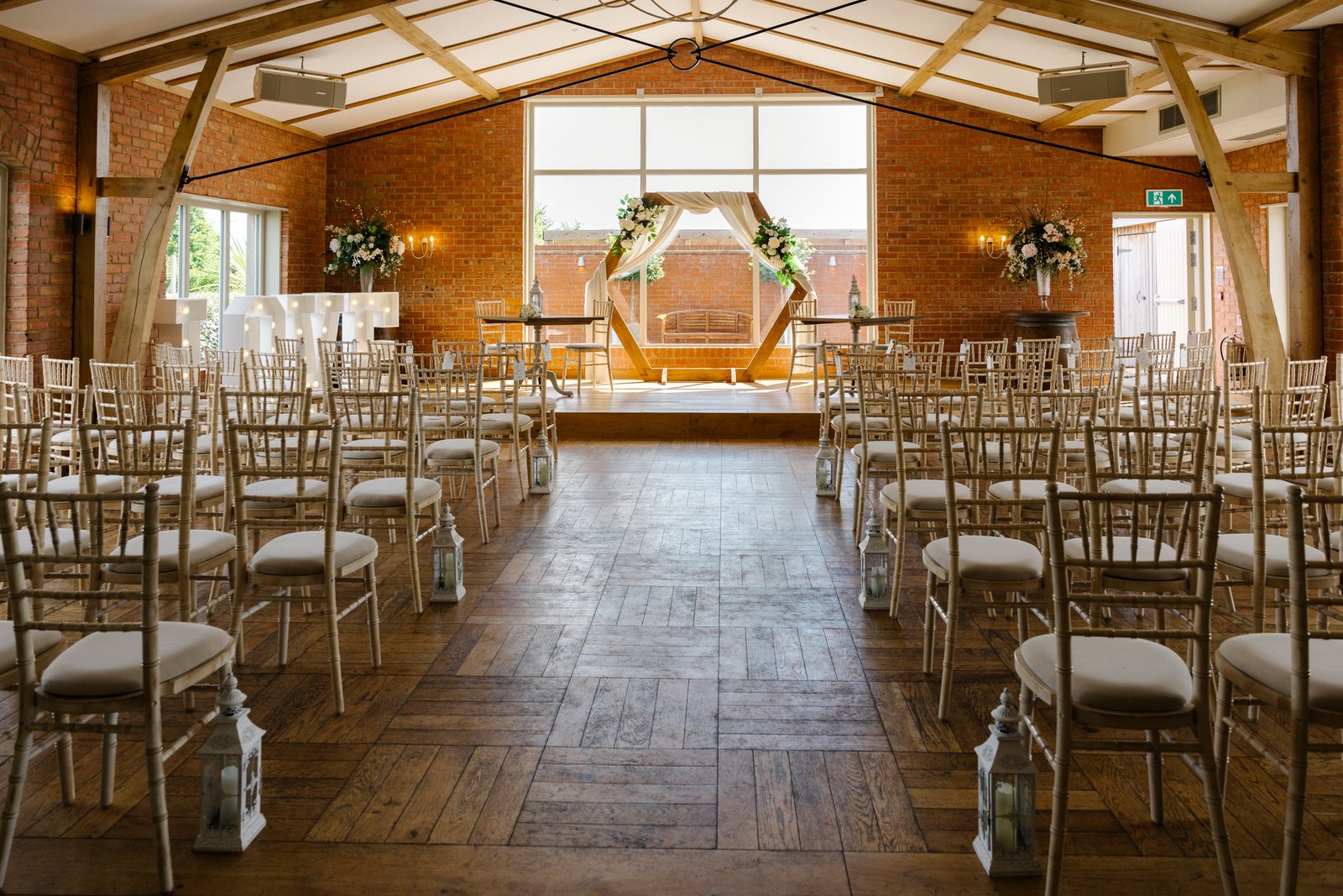 The ceremony room at Cider Mill Barns set with chairs and a wooden arch at the far end