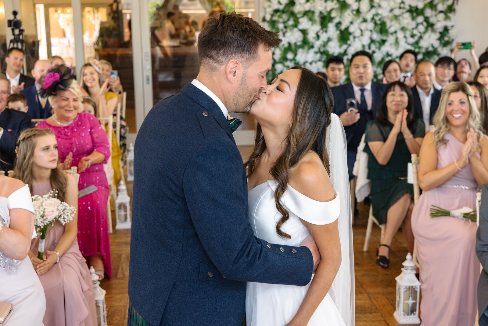 The couple's first kiss as their guests applaud