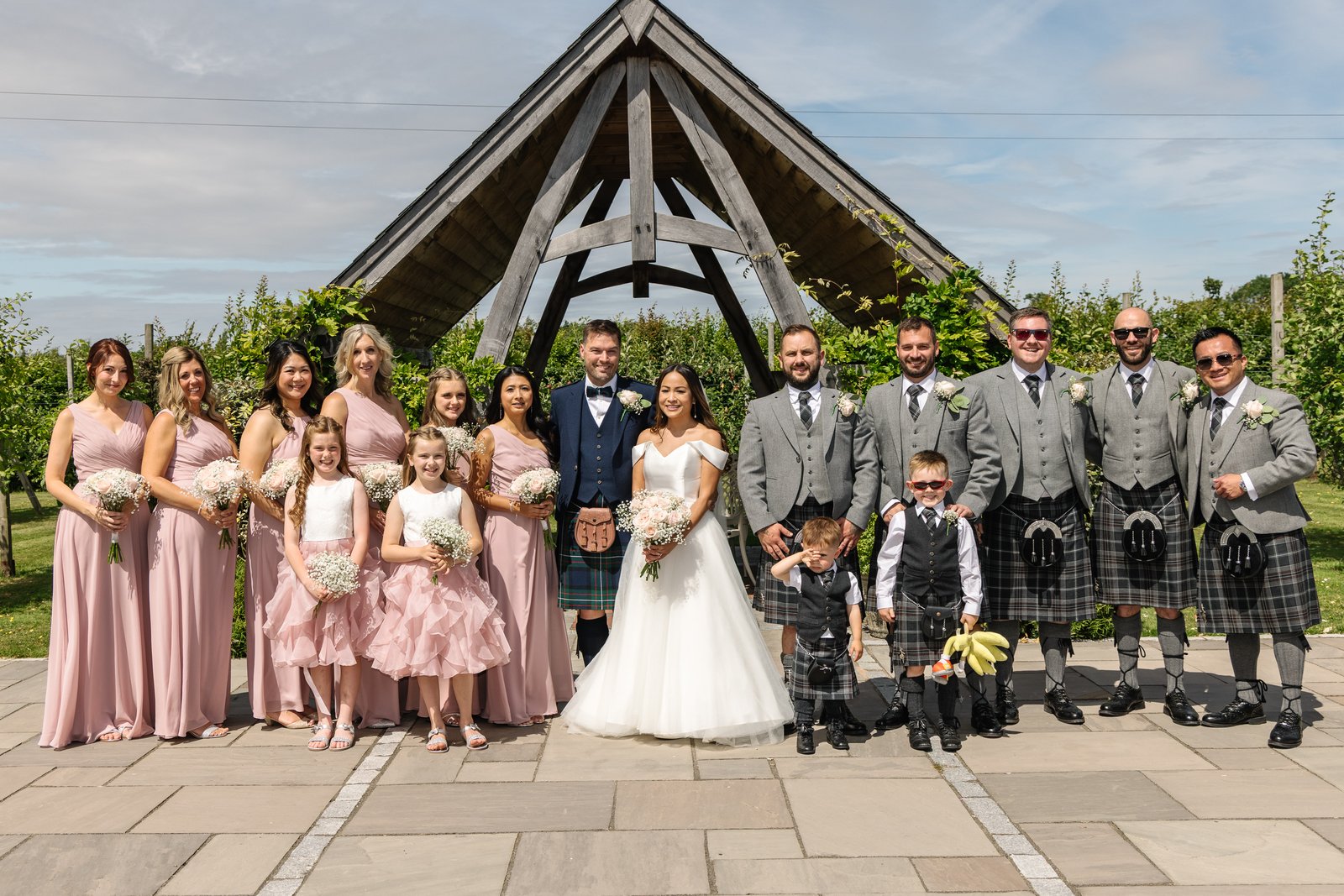 The bridal party lined up in front of the oak frame at Cider Mill Barns