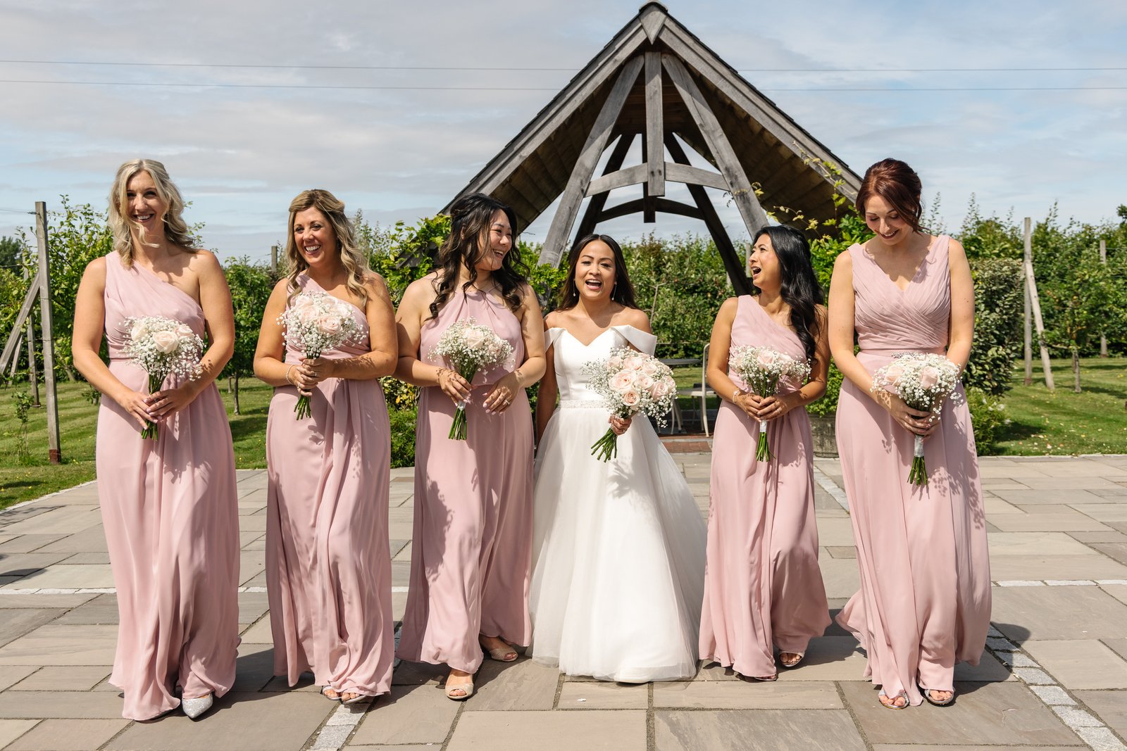 The bride and her bridesmaids walking across the terrace towards the camera