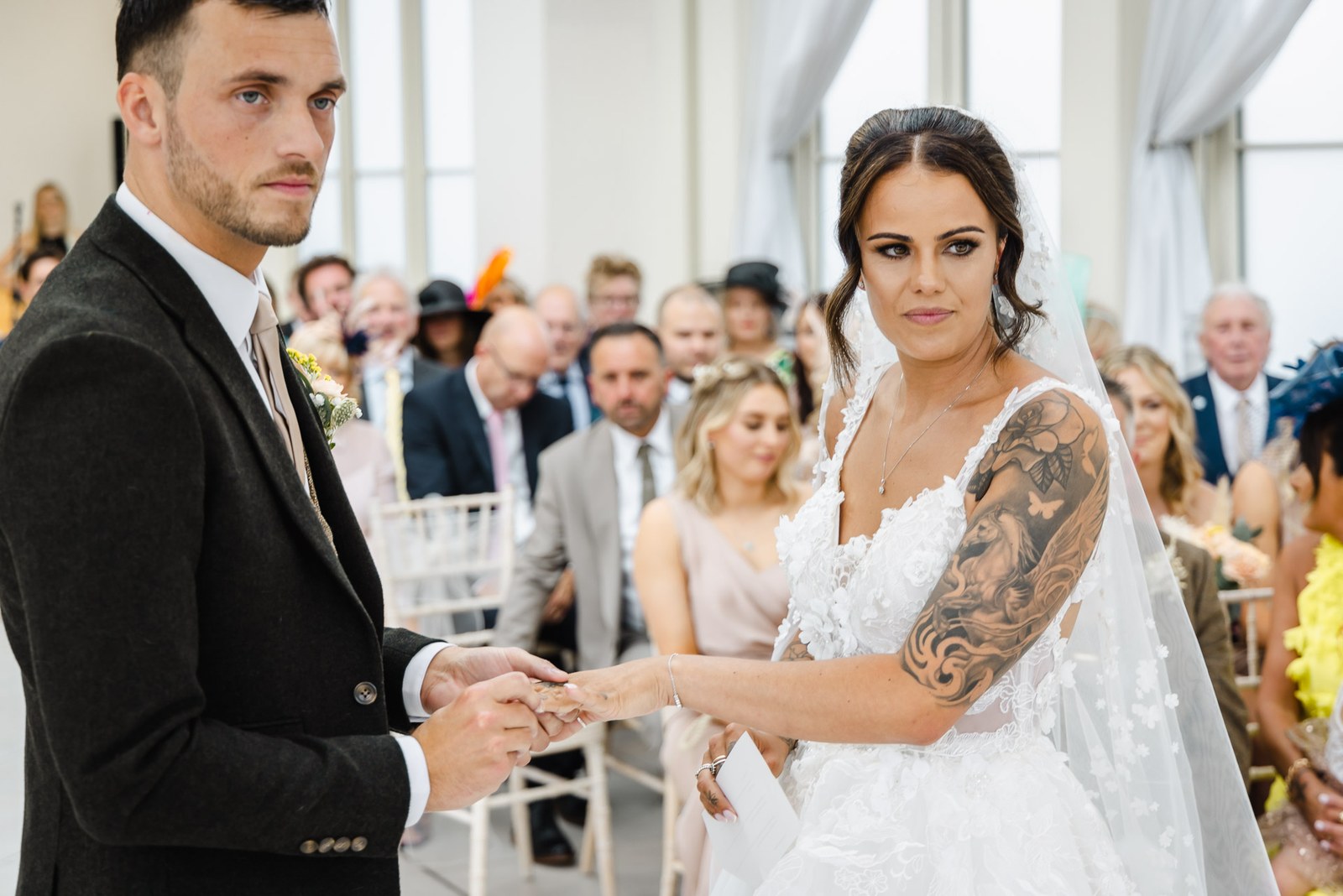 The groom slides the wedding ring onto the bride's finger