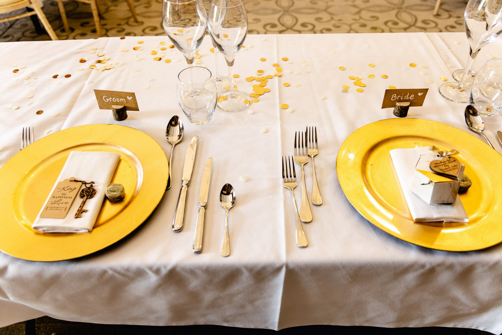 Gold charger plates and 'Bride' and 'Groom' name cards on the top table