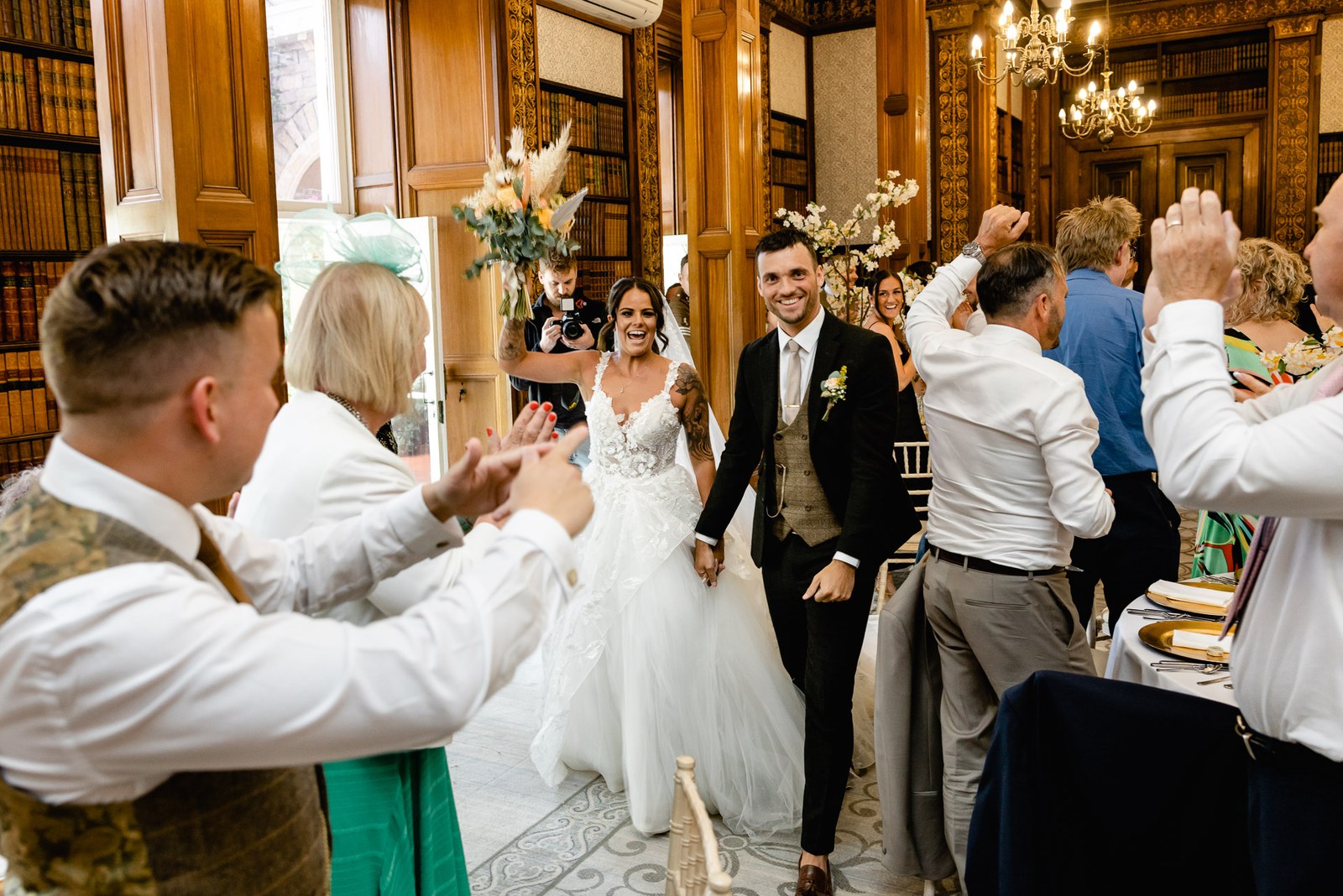 The couple enter the reception through a guard of applauding guests