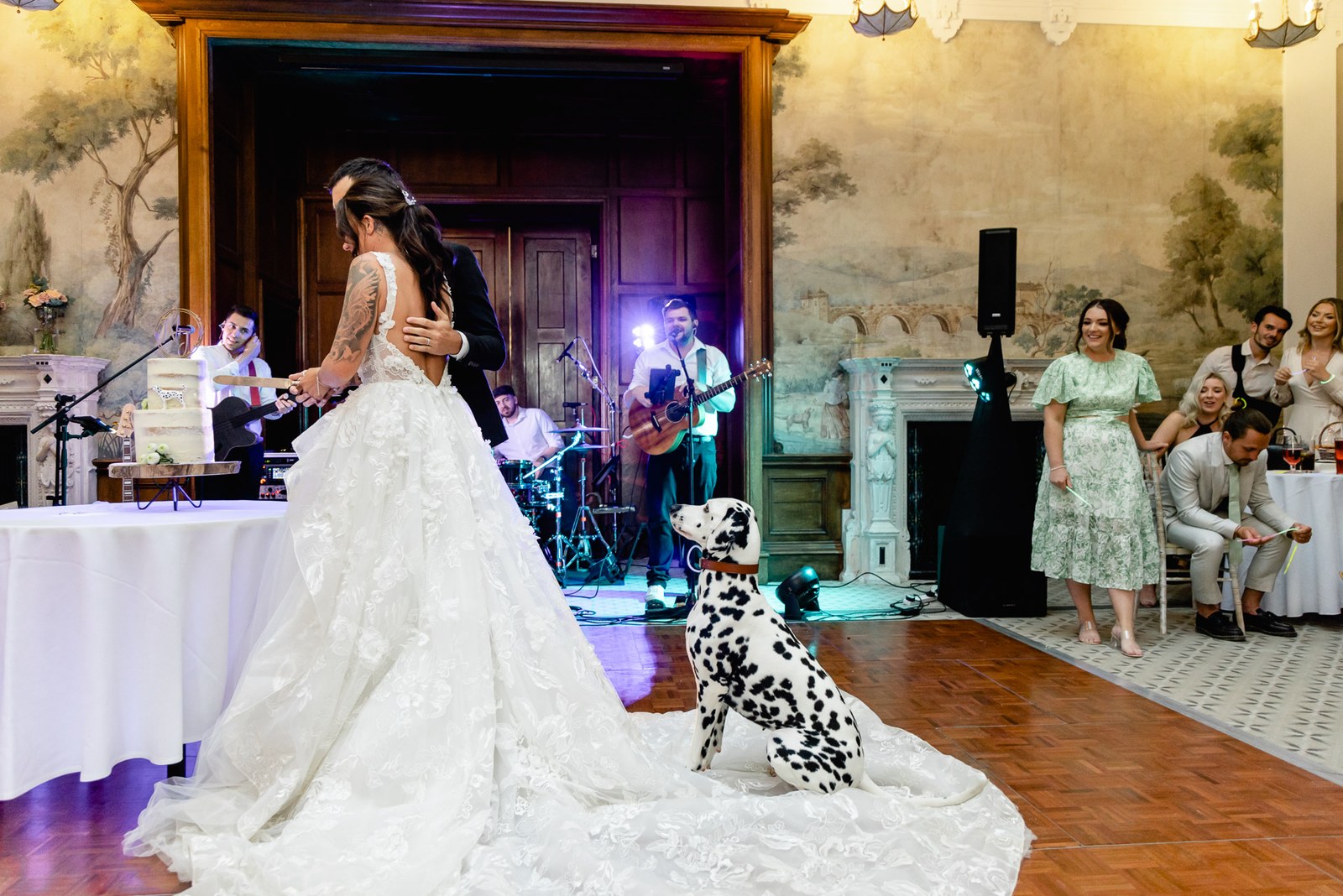 The couple dance before the cake as the Dalmatian sits and a band plays