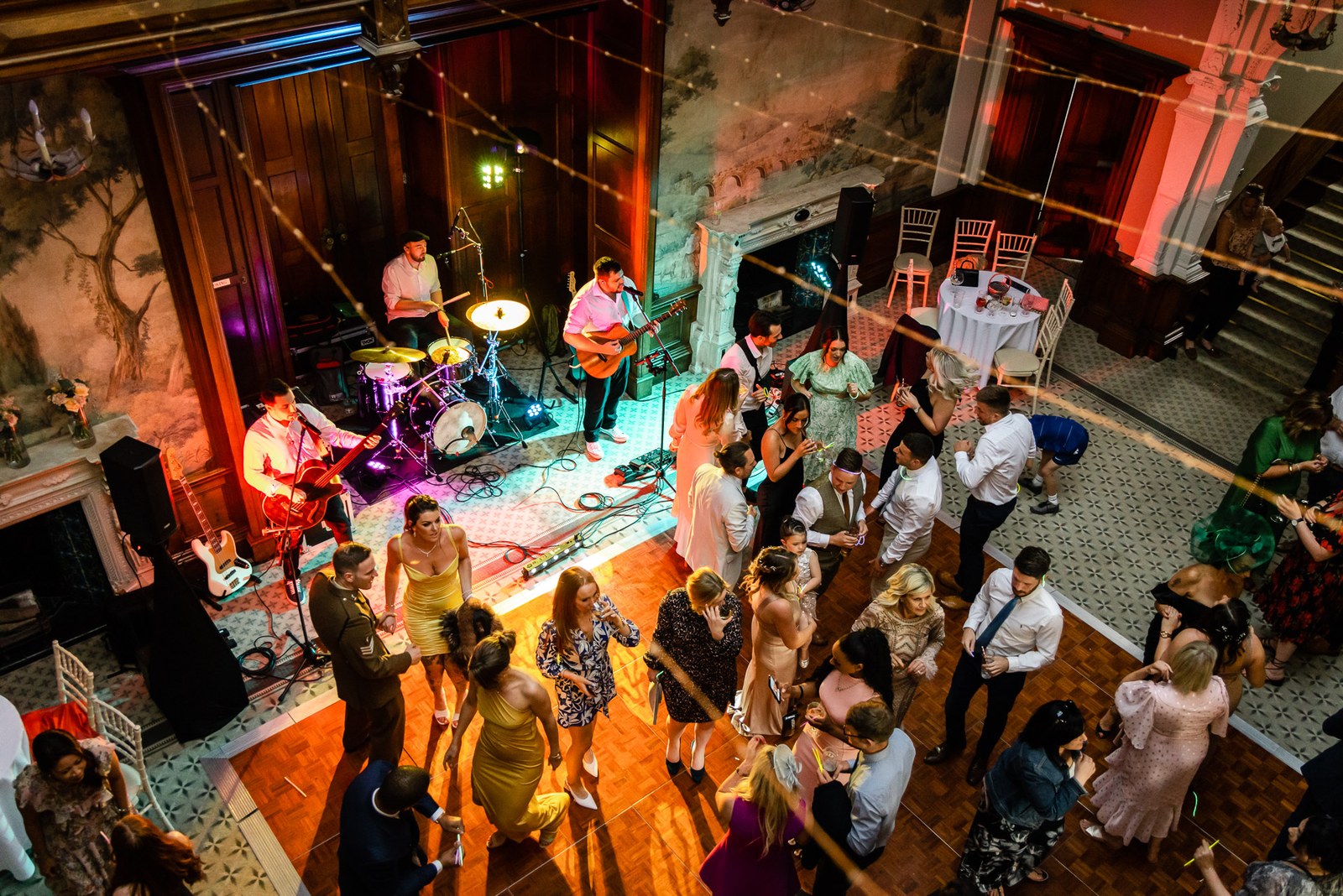 Elevated view of the reception as the band plays and guests fill the painted hall