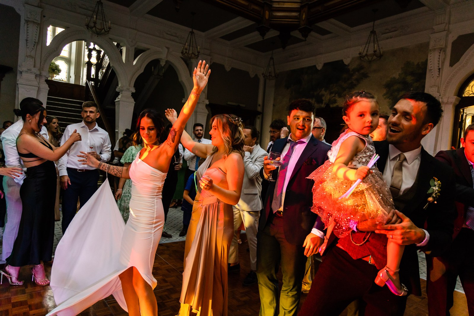 Guests dance together, a woman twirling and a child held aloft