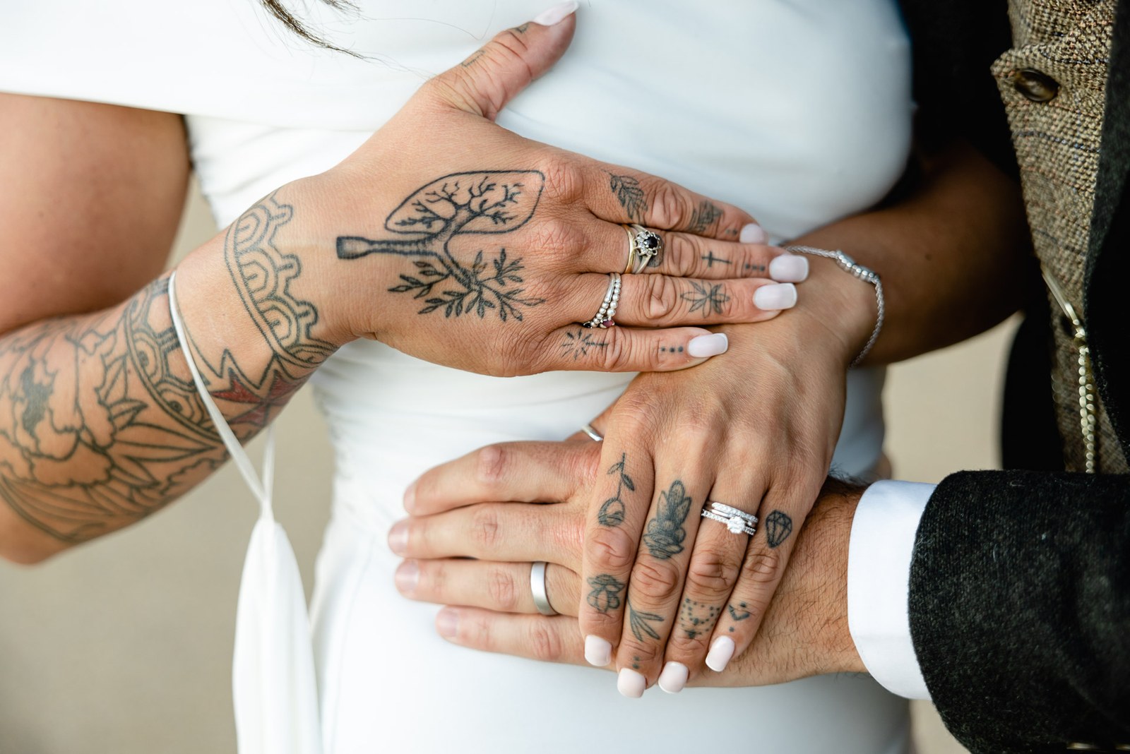 Close-up of the couple's hands at the bride's waist showing their wedding rings