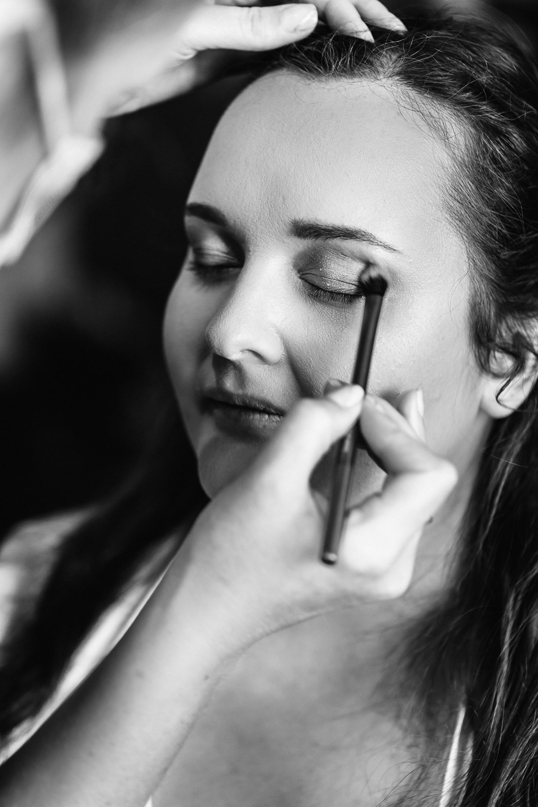Black-and-white close-up of eye makeup being applied during the morning preparations