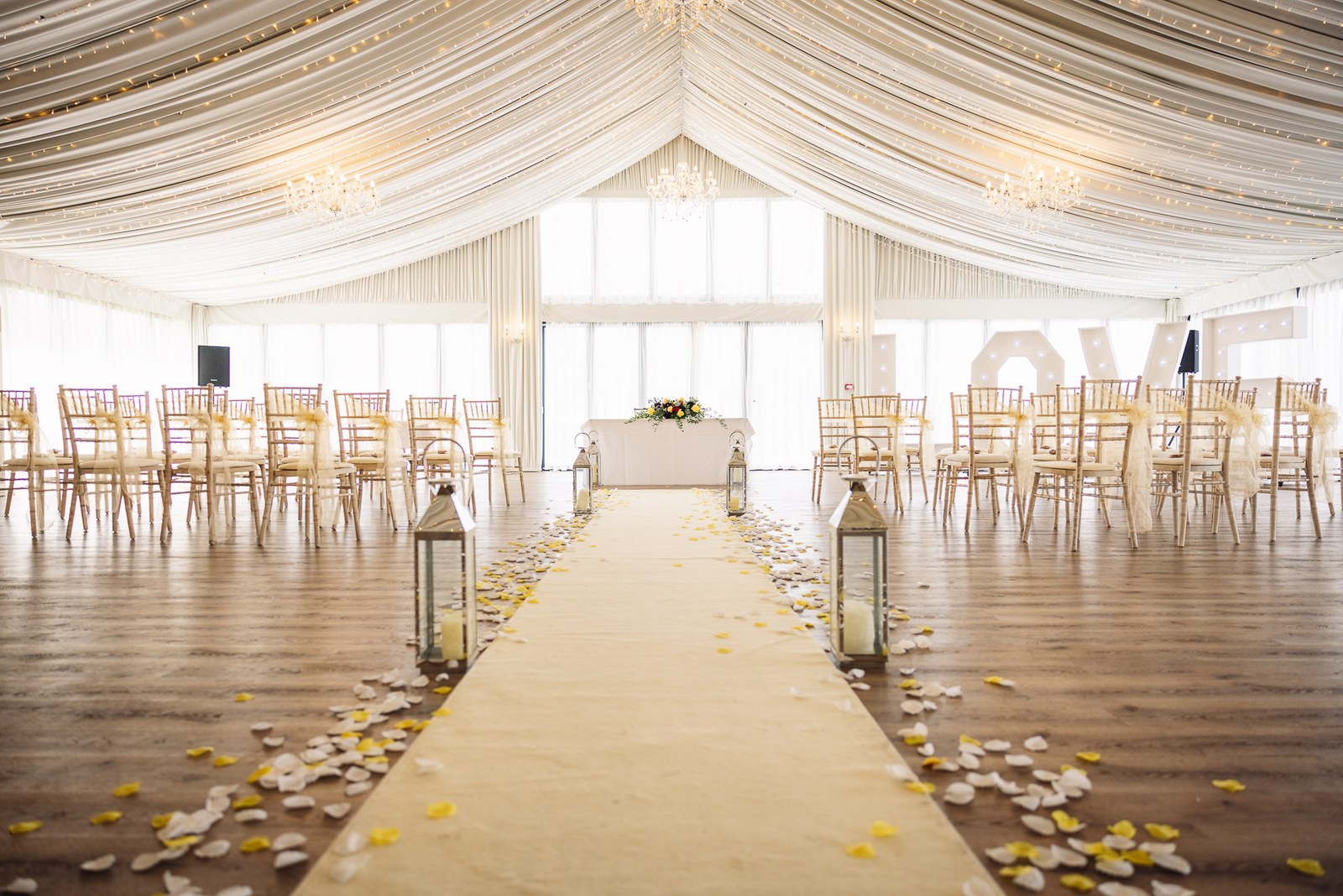The draped ceremony pavilion at Cotswolds Hotel & Spa set with chairs and a petal-strewn aisle