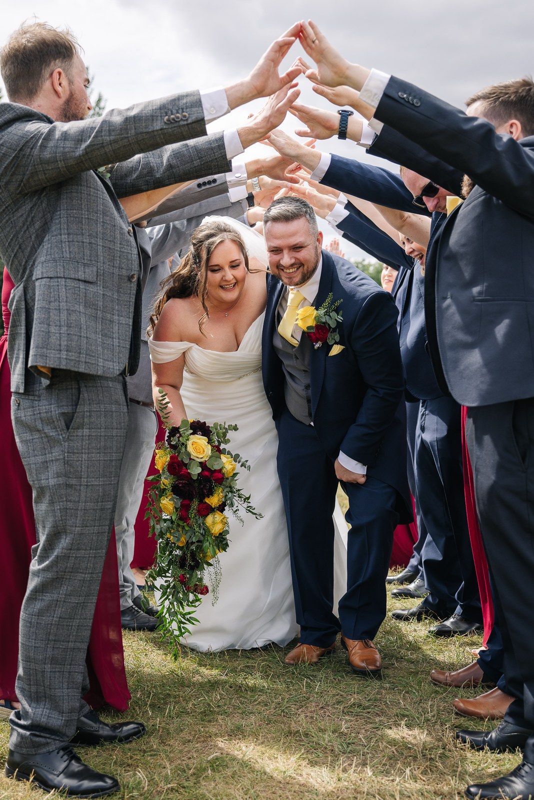 The newlyweds walk beneath a guard of honour's raised arms