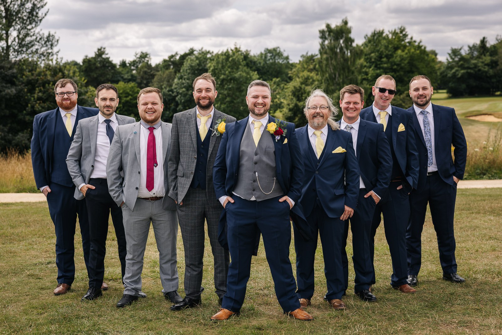 The groom and groomsmen in navy and grey suits on the golf course at Cotswolds Hotel & Spa