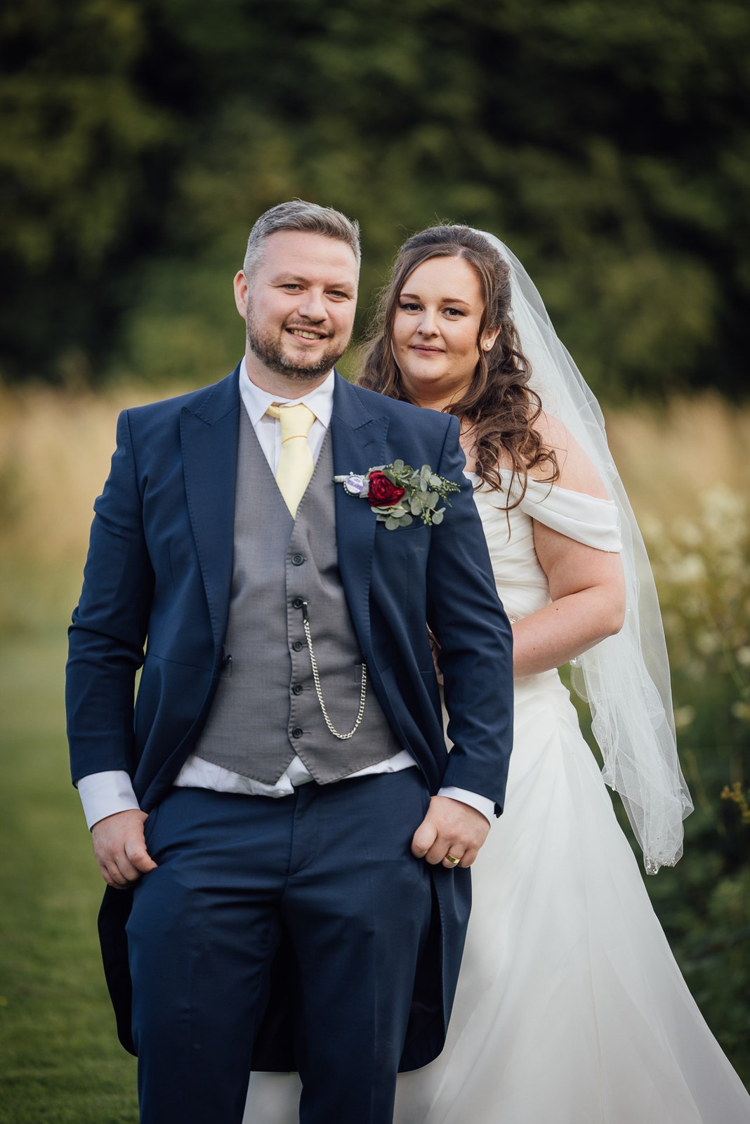 Portrait of the couple standing together on the lawn at Cotswolds Hotel & Spa