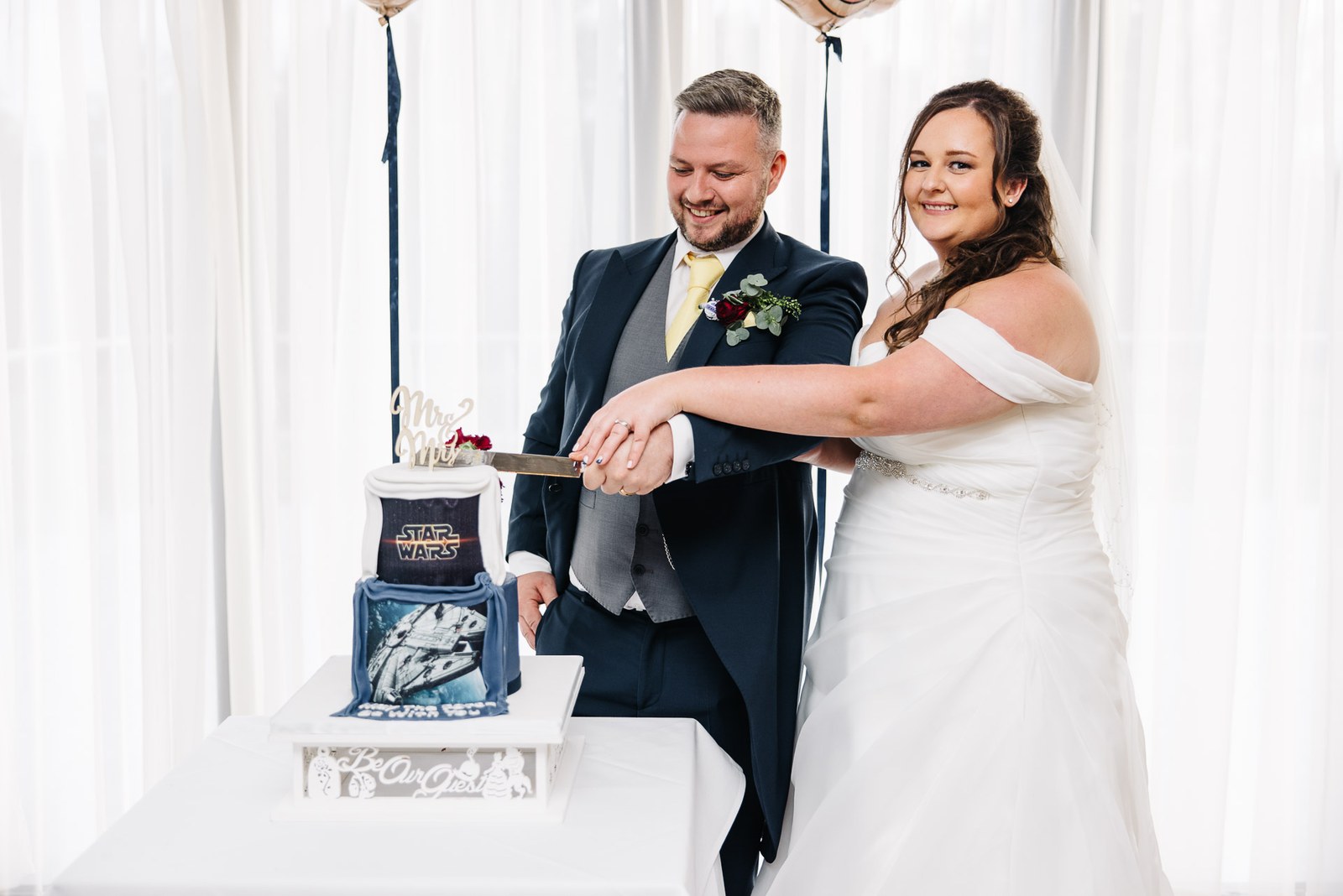 Bride and groom cut their tiered Star Wars themed wedding cake