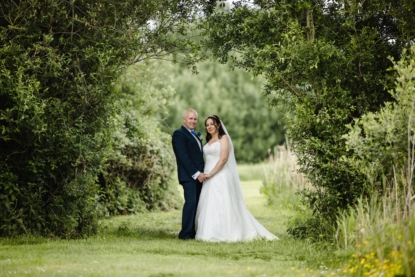 The newlyweds framed by a natural archway of trees