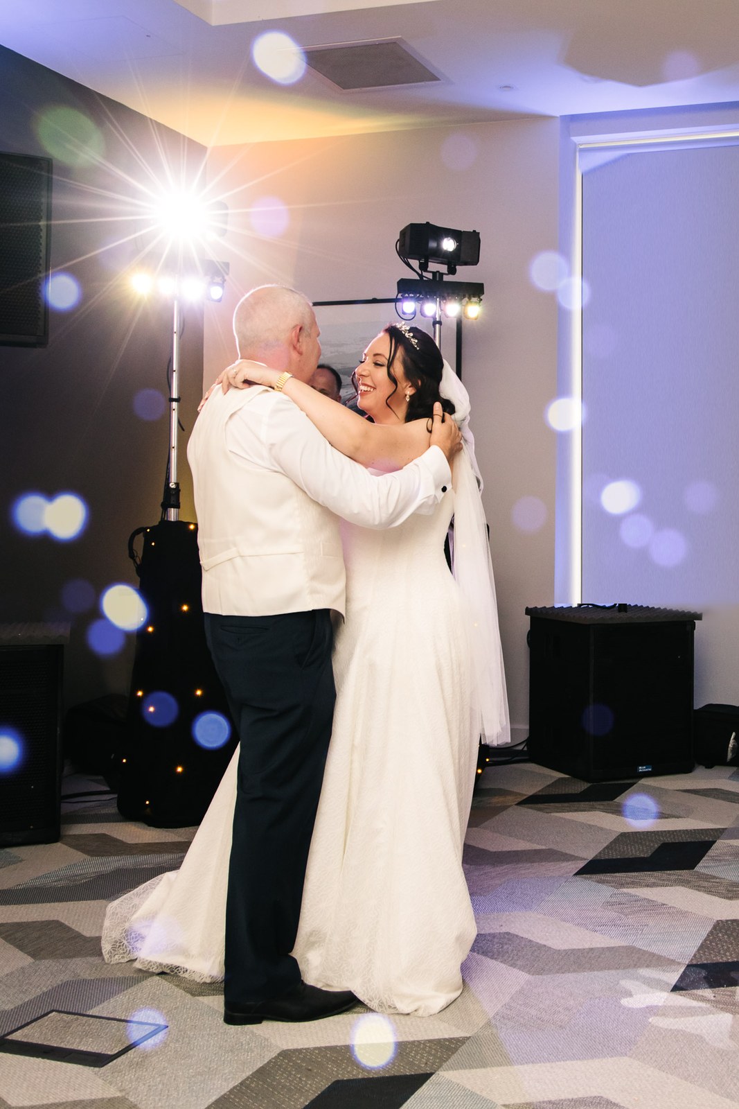 The couple share their first dance under coloured lights in the Courtyard by Marriott Oxford South suite