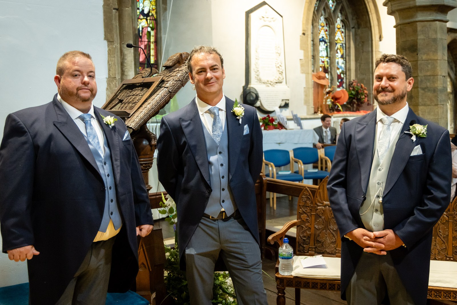 The groom and his groomsmen wait at the front of the church