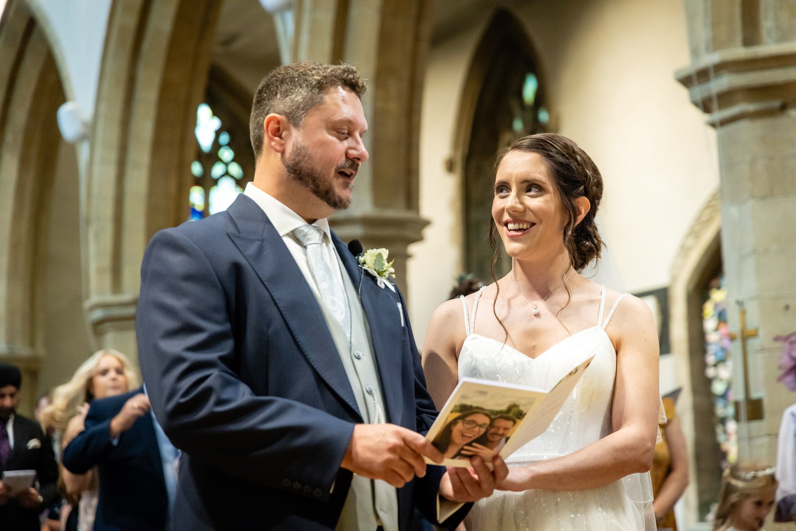 The bride joins the groom at the altar, holding her order of service