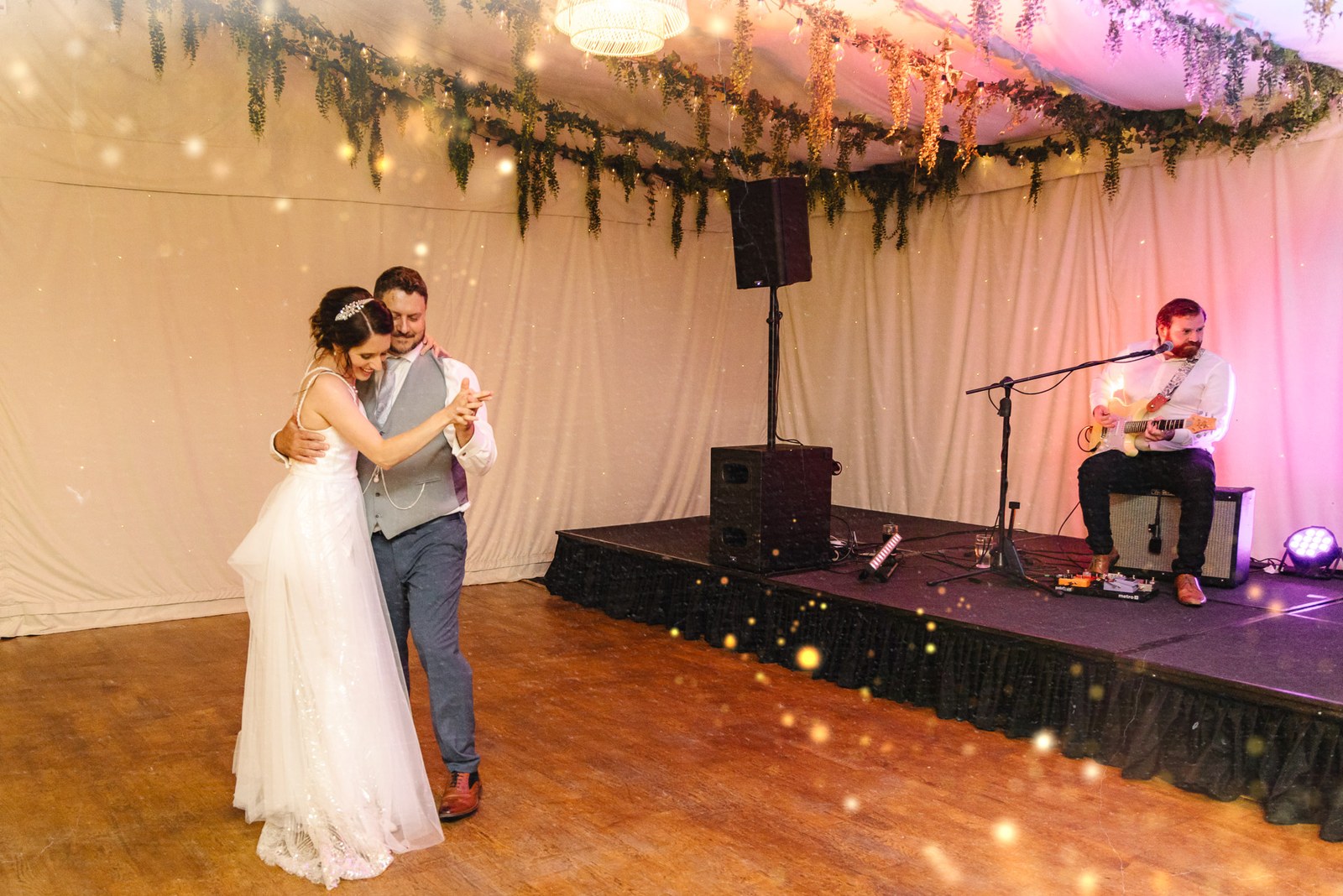 Bride and groom share their first dance as the band plays on stage