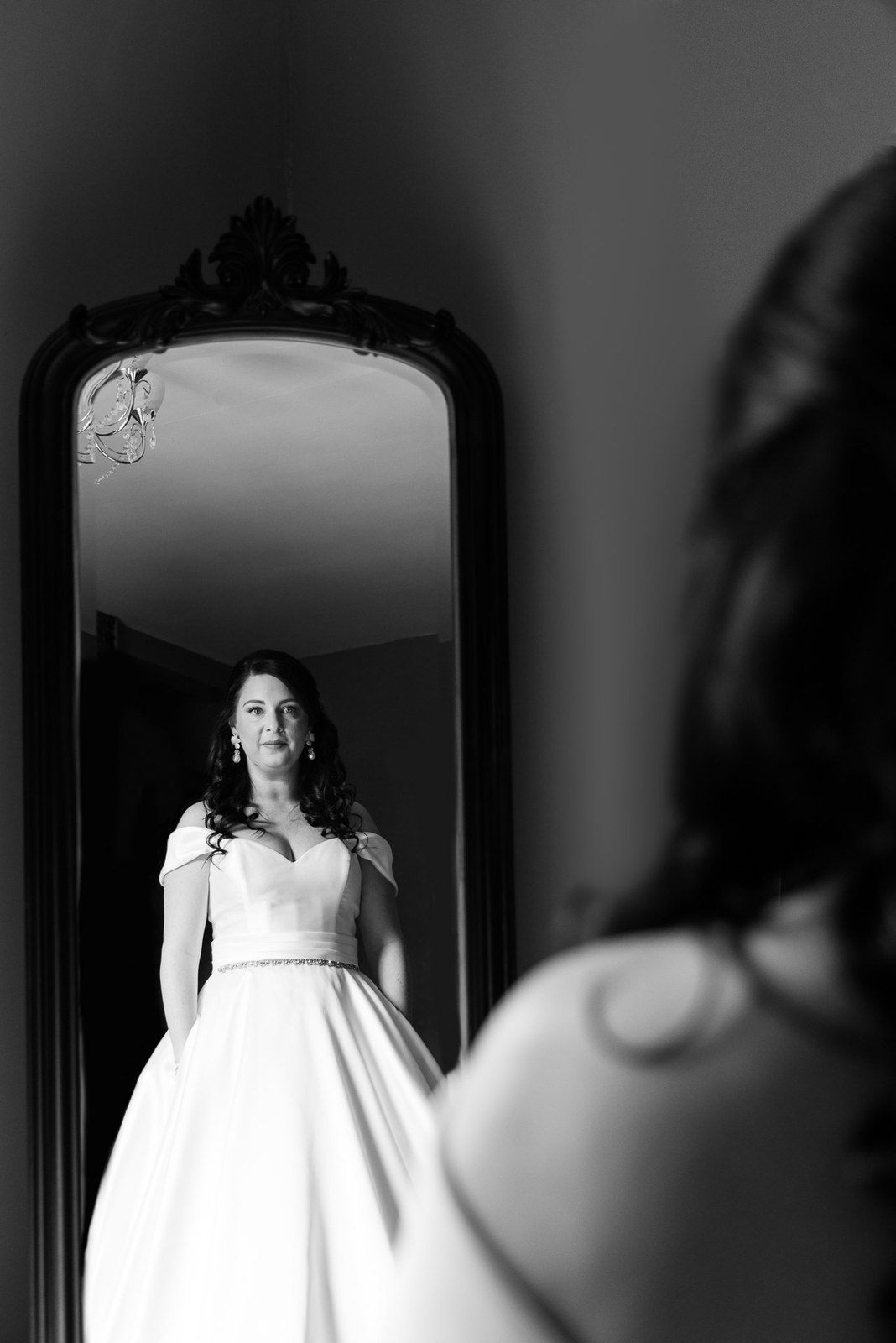 Black-and-white reflection of the bride in a tall mirror
