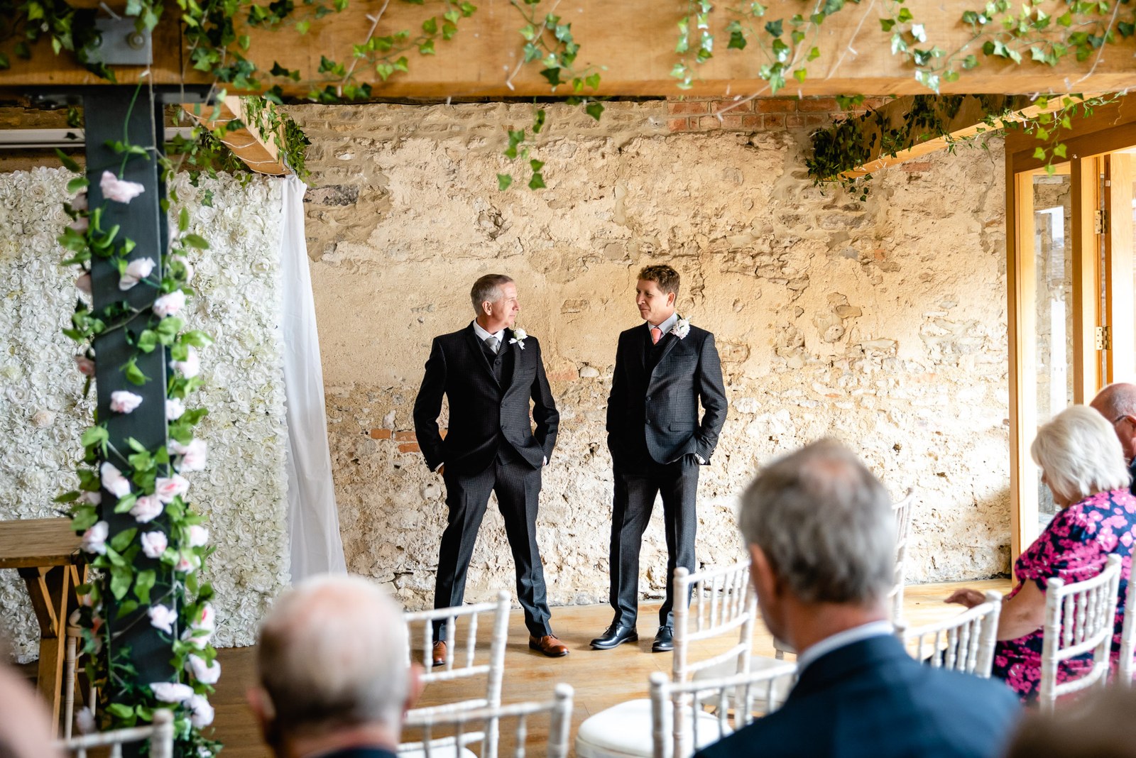 The groom and best man wait in the ivy-draped stone ceremony room at the Crown & Thistle
