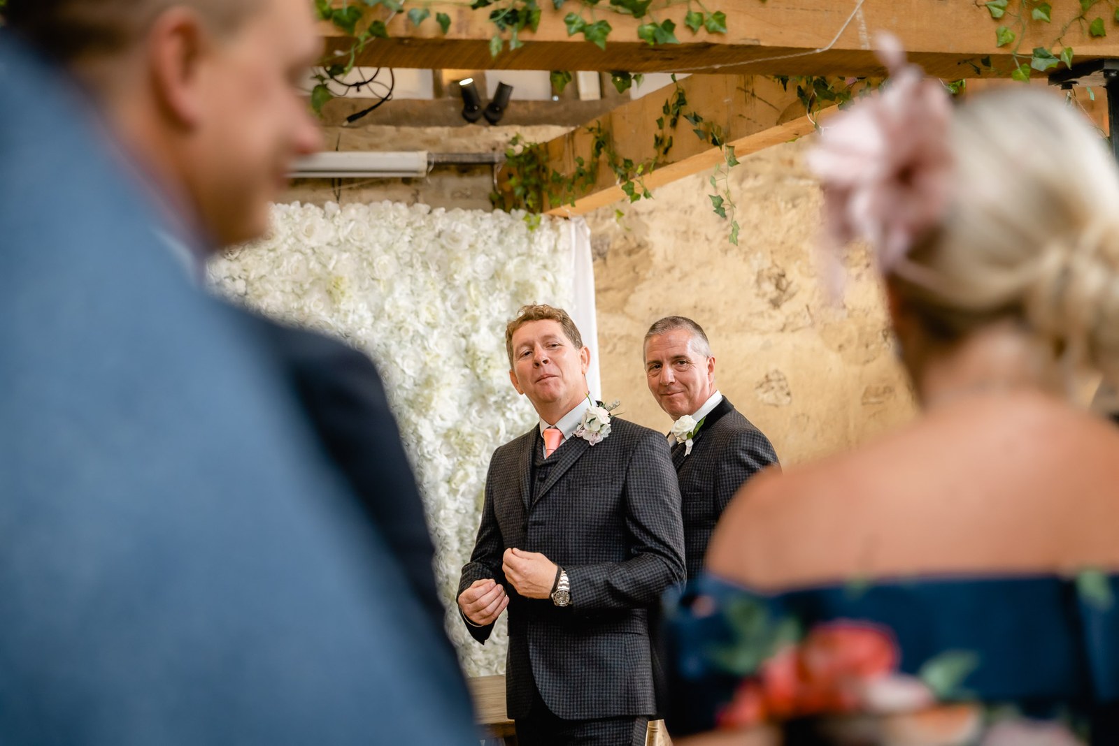 The groom watches over his shoulder as the bride approaches