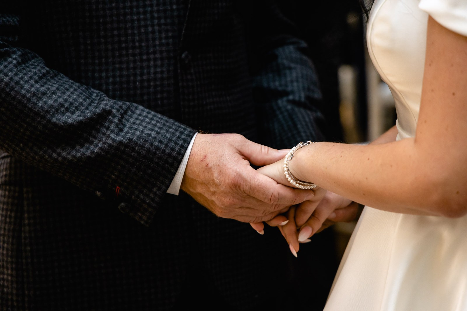 Close-up of the couple's hands clasped during the ceremony