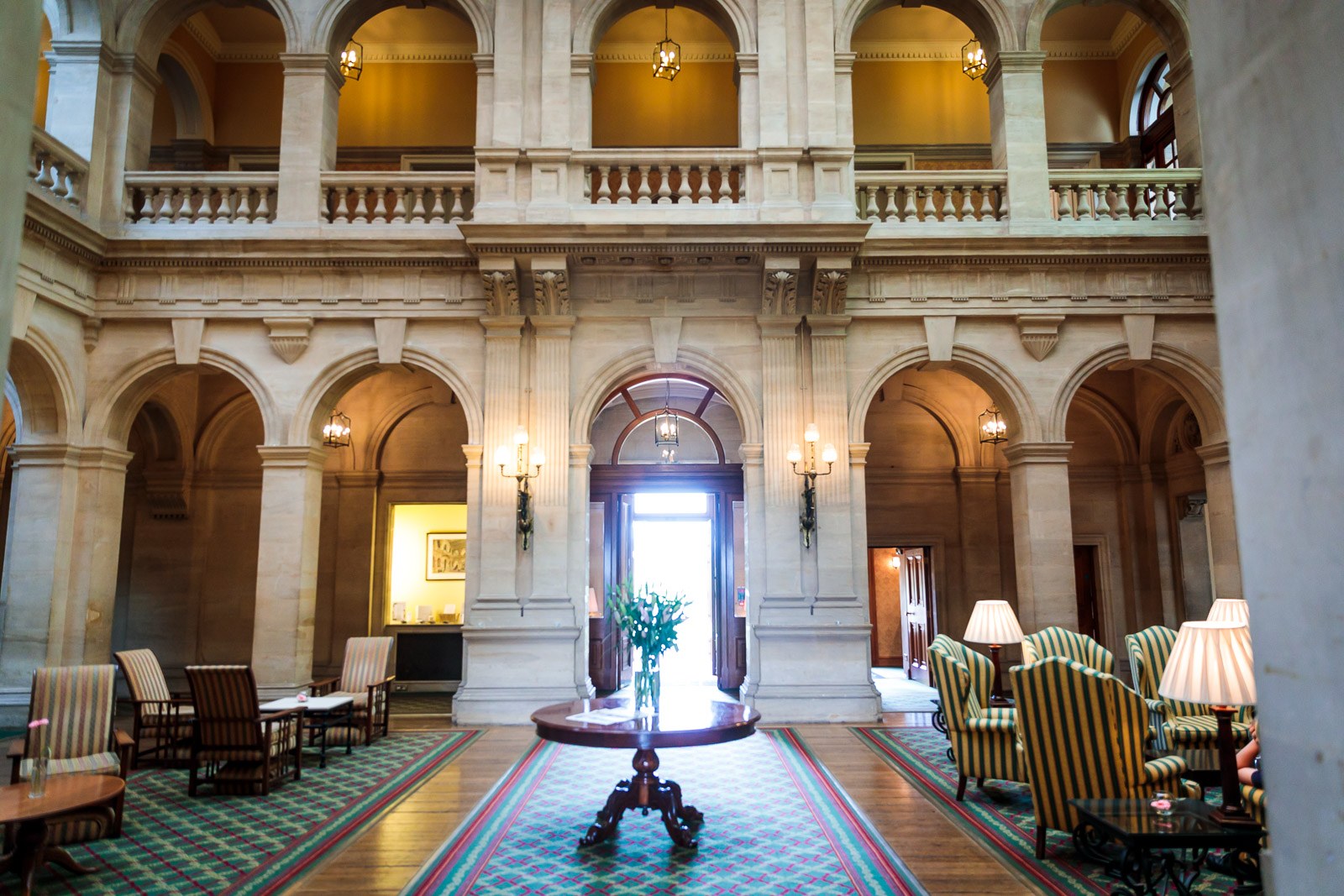The grand arched and columned lobby of Heythrop Park with lamplit sofas
