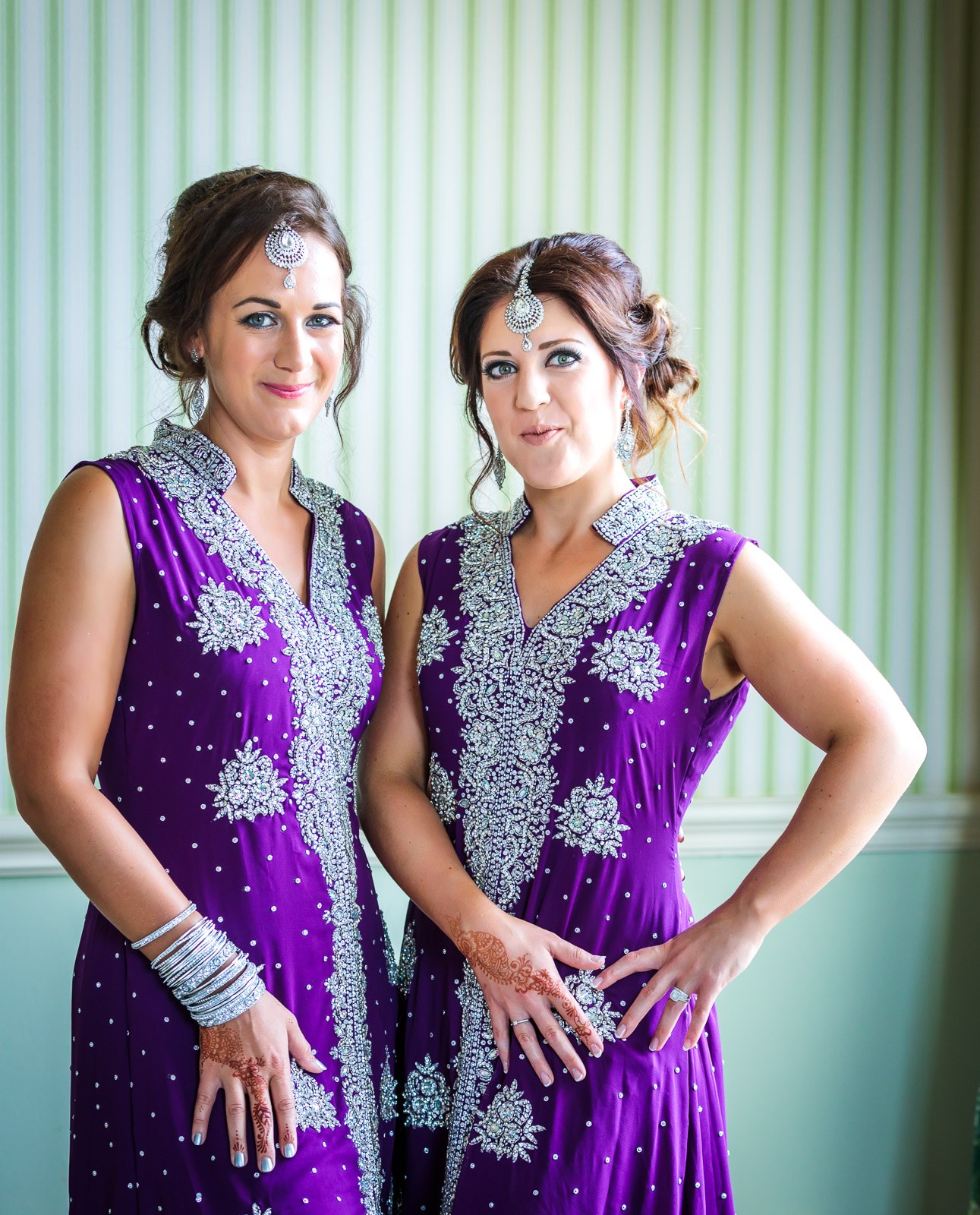Two women pose together in embellished purple outfits