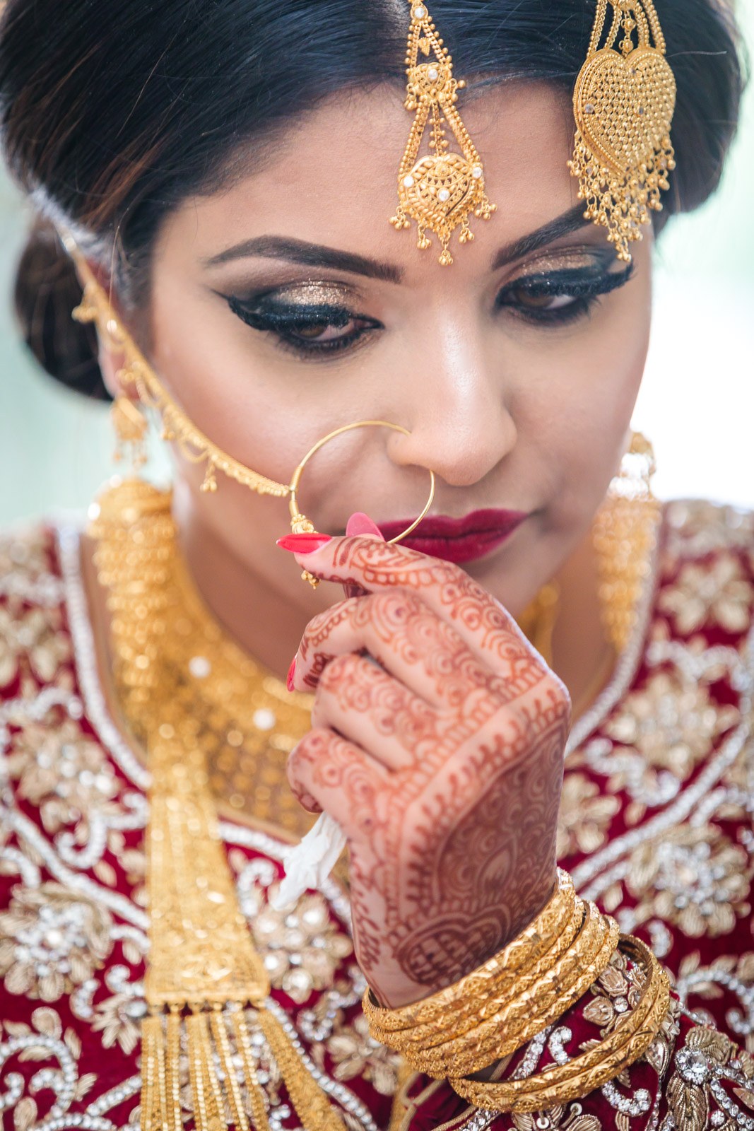 Close-up of the bride wearing a gold nose ring and headpiece