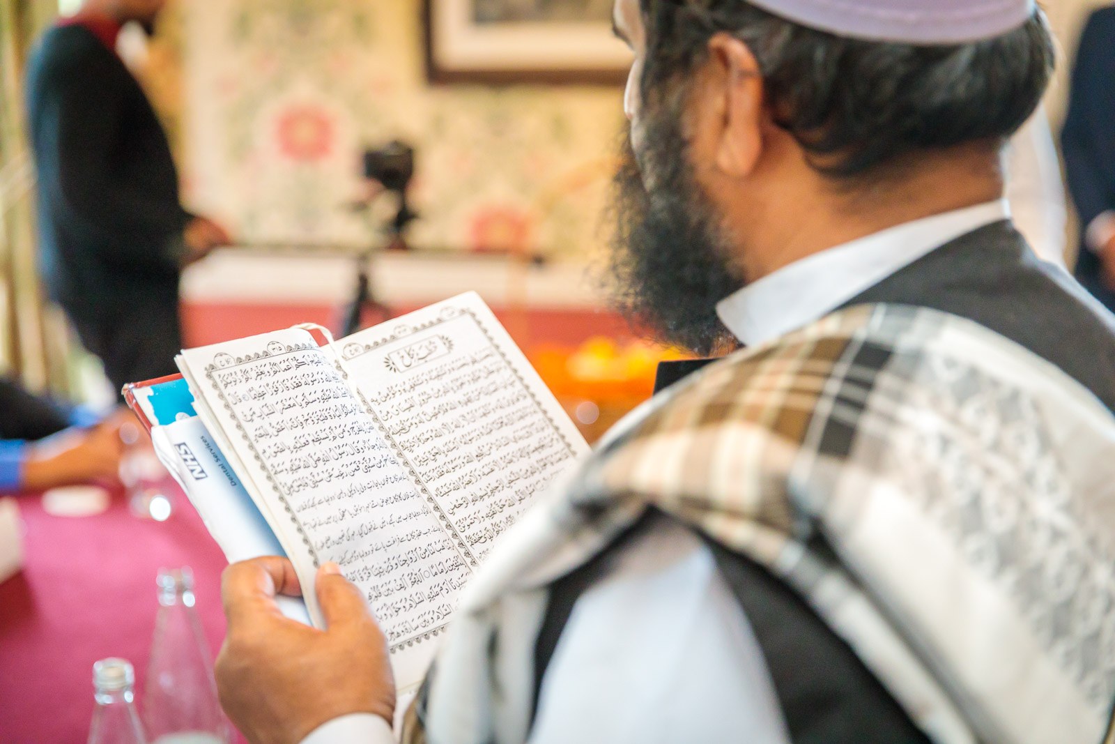 Close-up of an elder reading from the Quran during the ceremony