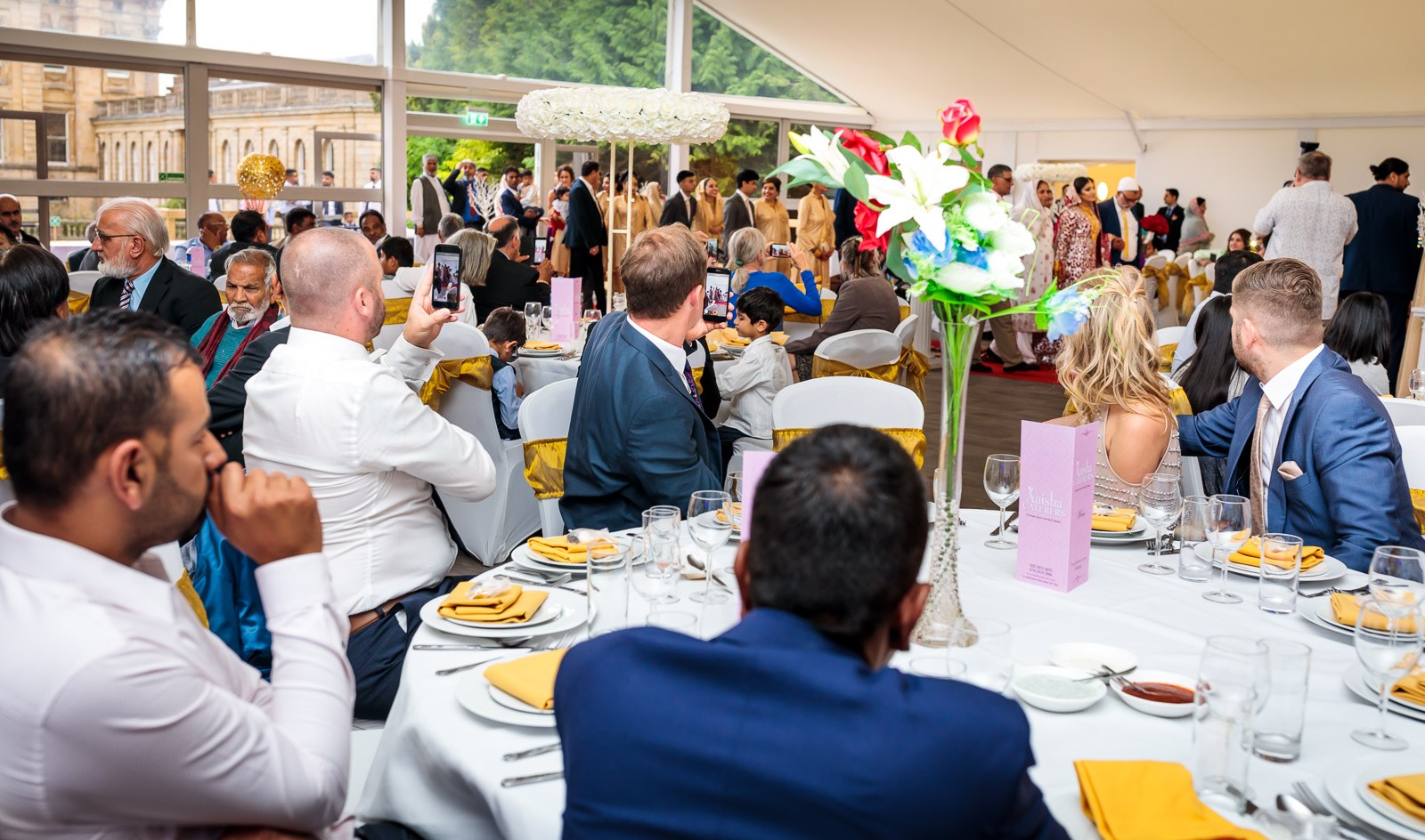 Guests seated at round tables in the reception marquee
