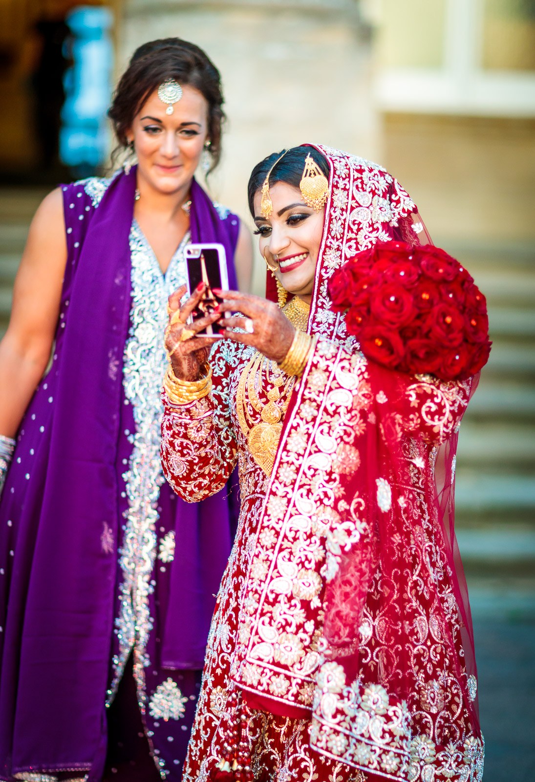 The bride takes a selfie with a guest in purple