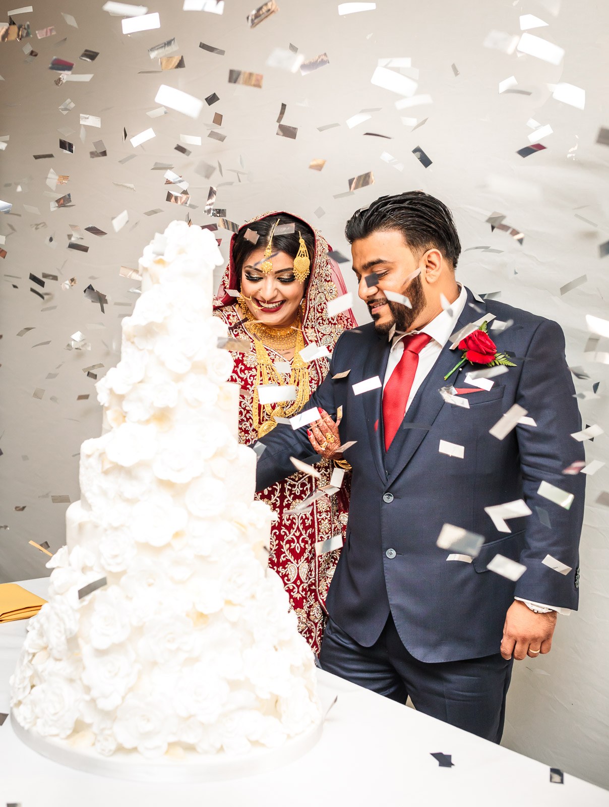 The couple cut their towering white rose cake amid a shower of confetti