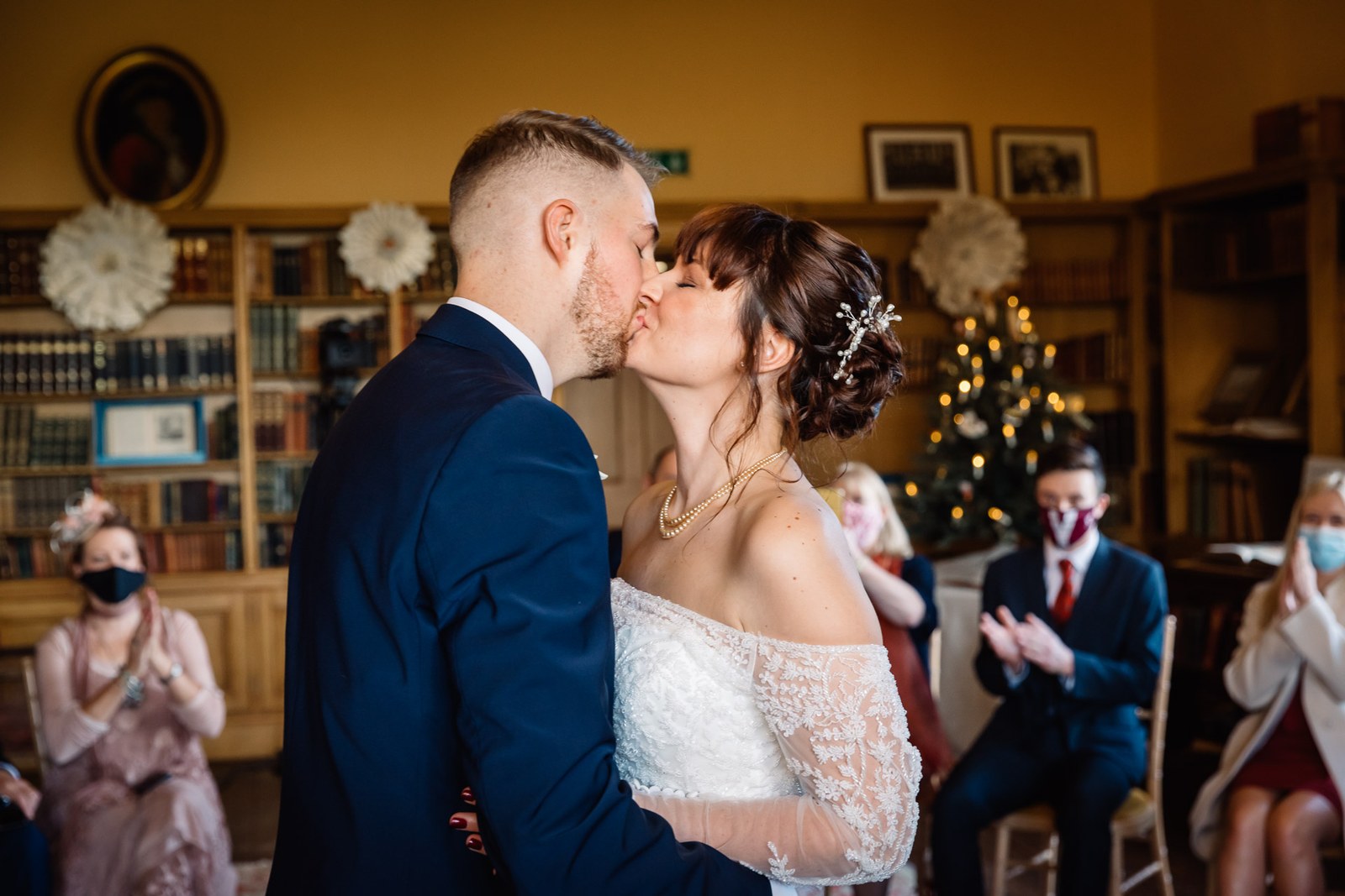 The newlyweds share their first kiss as guests applaud