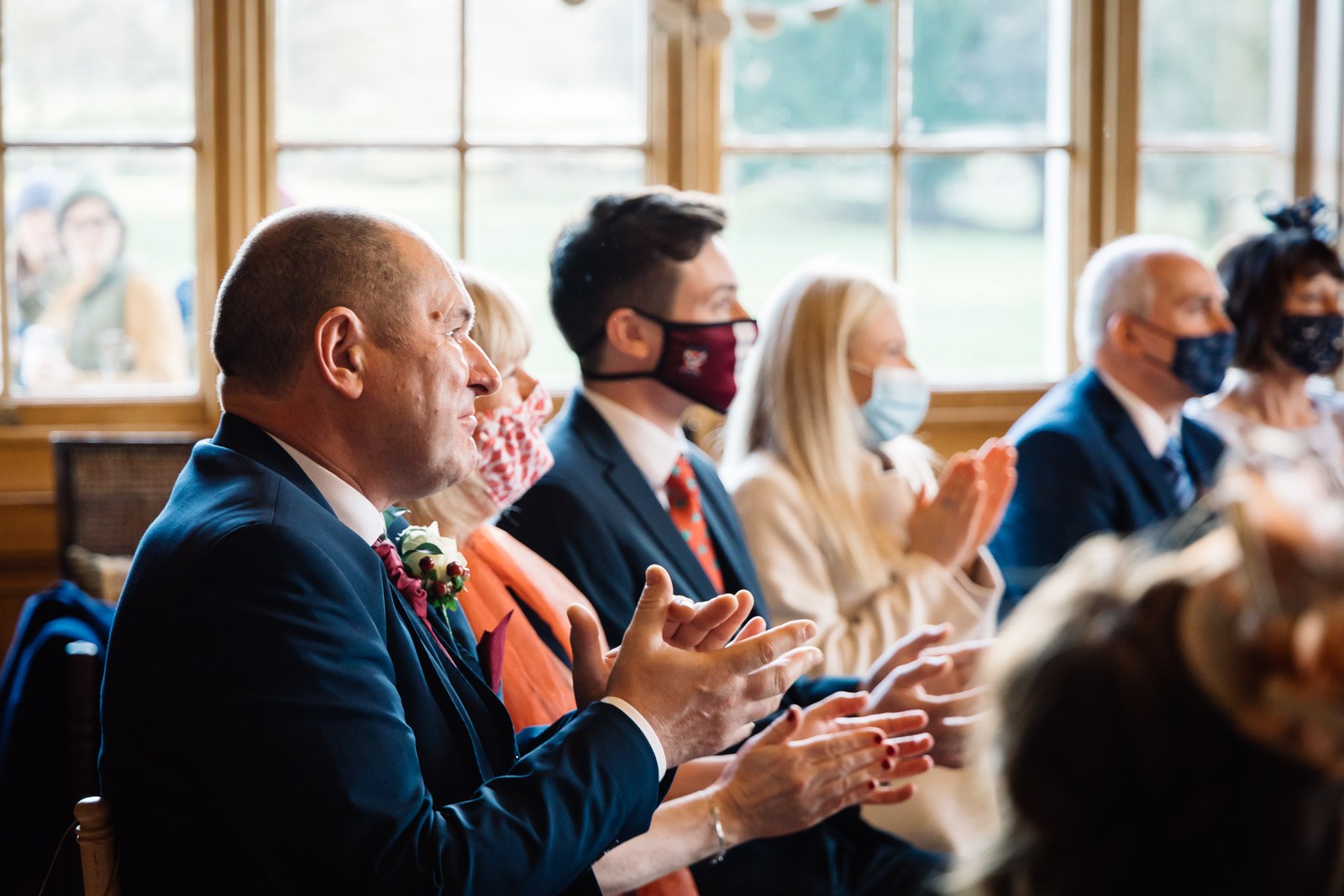 Guests applaud from their seats by the window