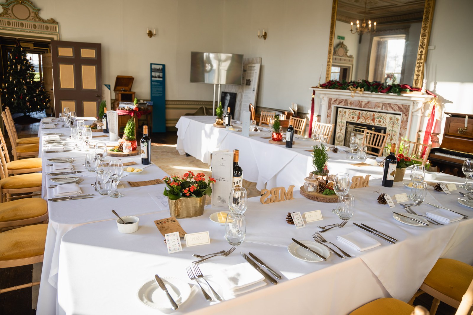 The reception room at Delapre Abbey laid with a long white-clothed table by the fireplace