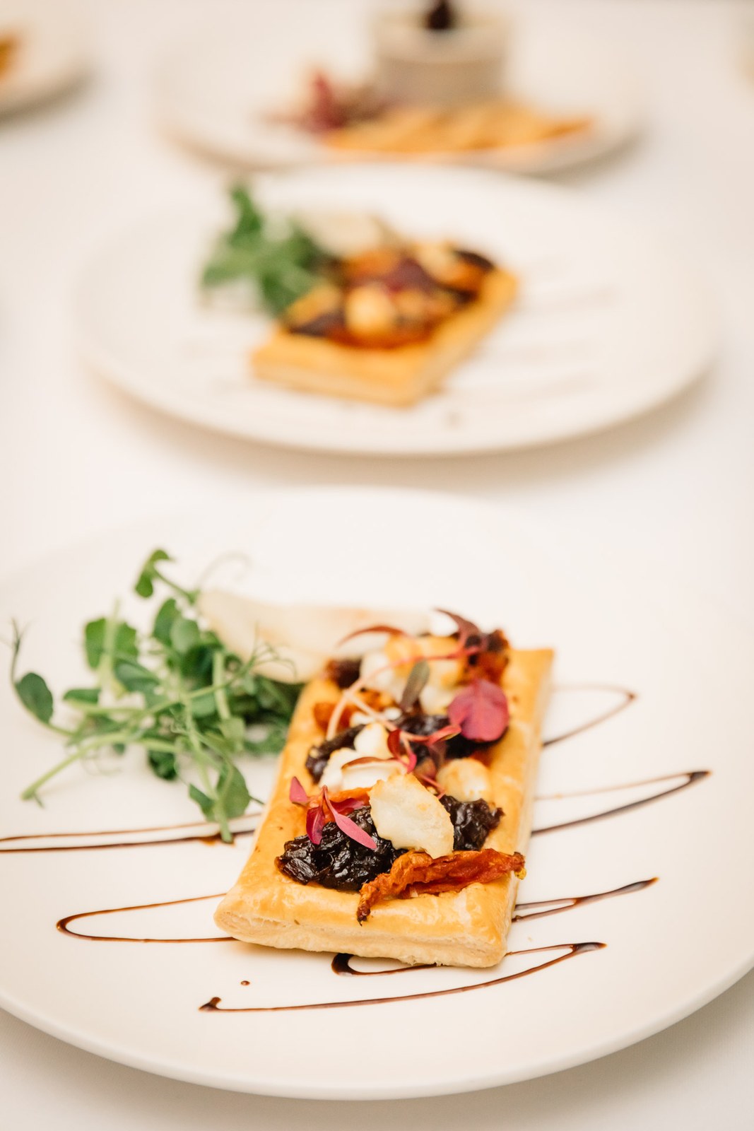 Close-up of a plated pastry starter dressed with salad and balsamic