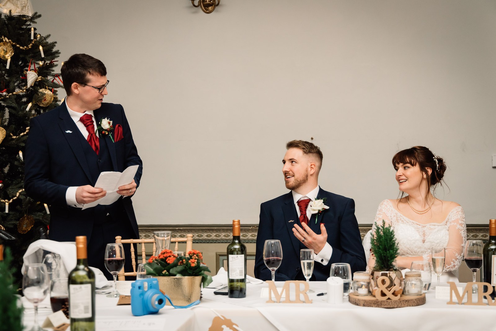A speaker reads his speech as the couple sit by the Christmas tree