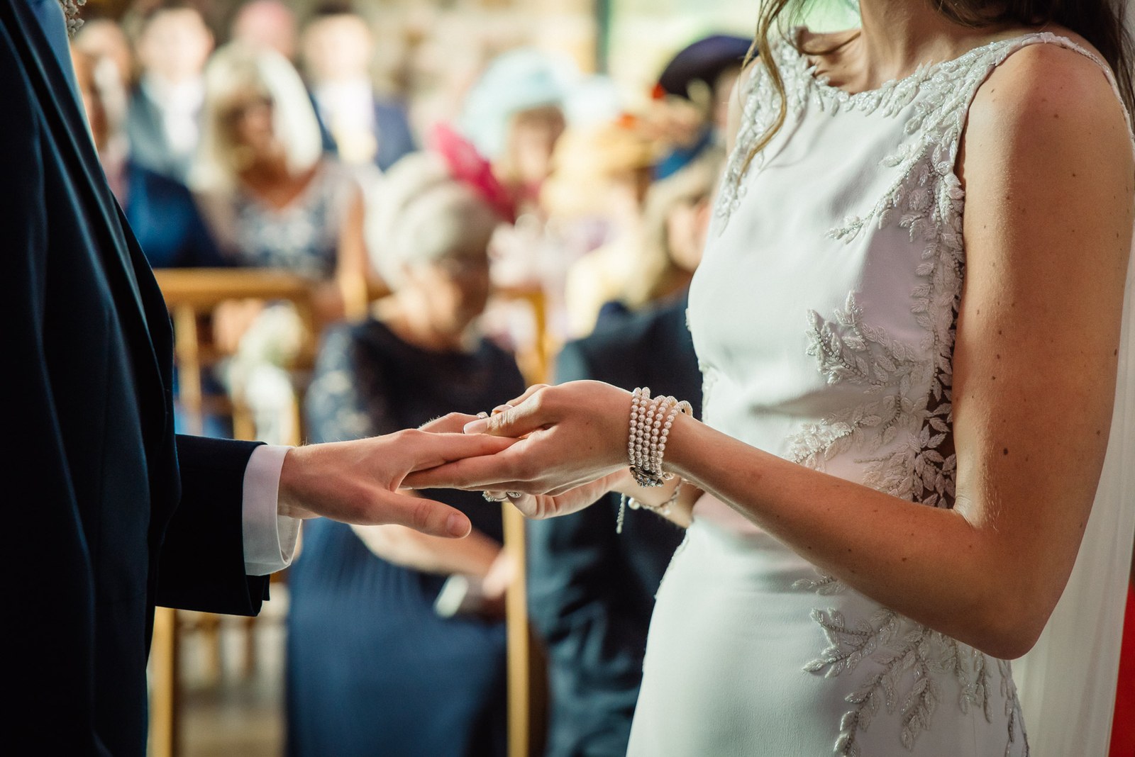Close-up of the ring being placed on the groom's finger during the ceremony