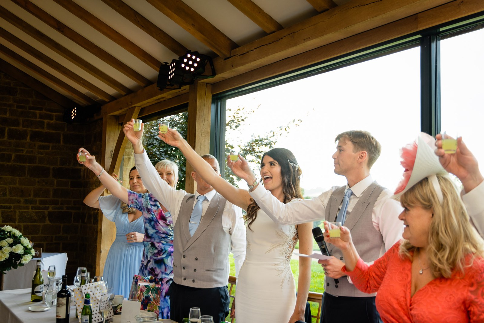 Guests raising their glasses for a toast in Dodford Manor's timber-framed reception room