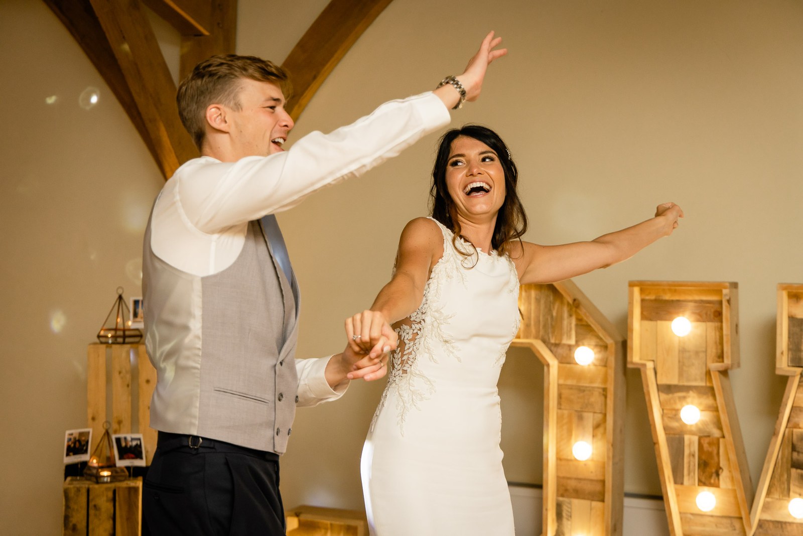 The couple dancing energetically before the glowing LOVE letters
