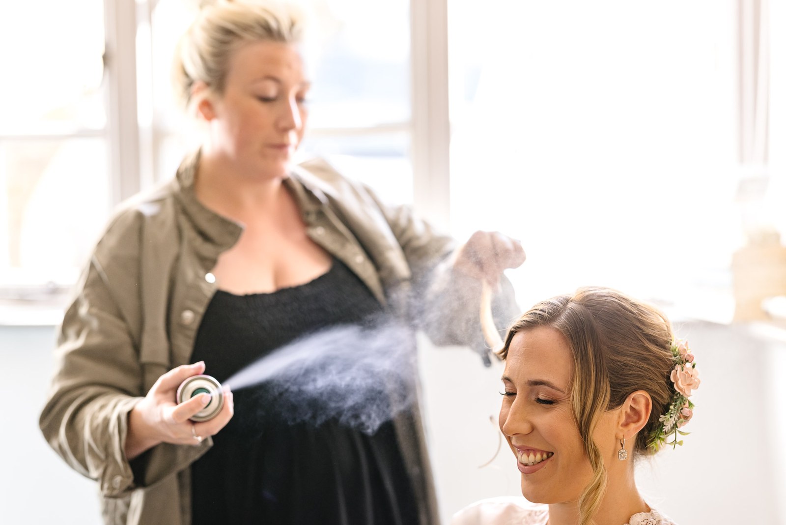 A cloud of hairspray setting the bride's floral updo