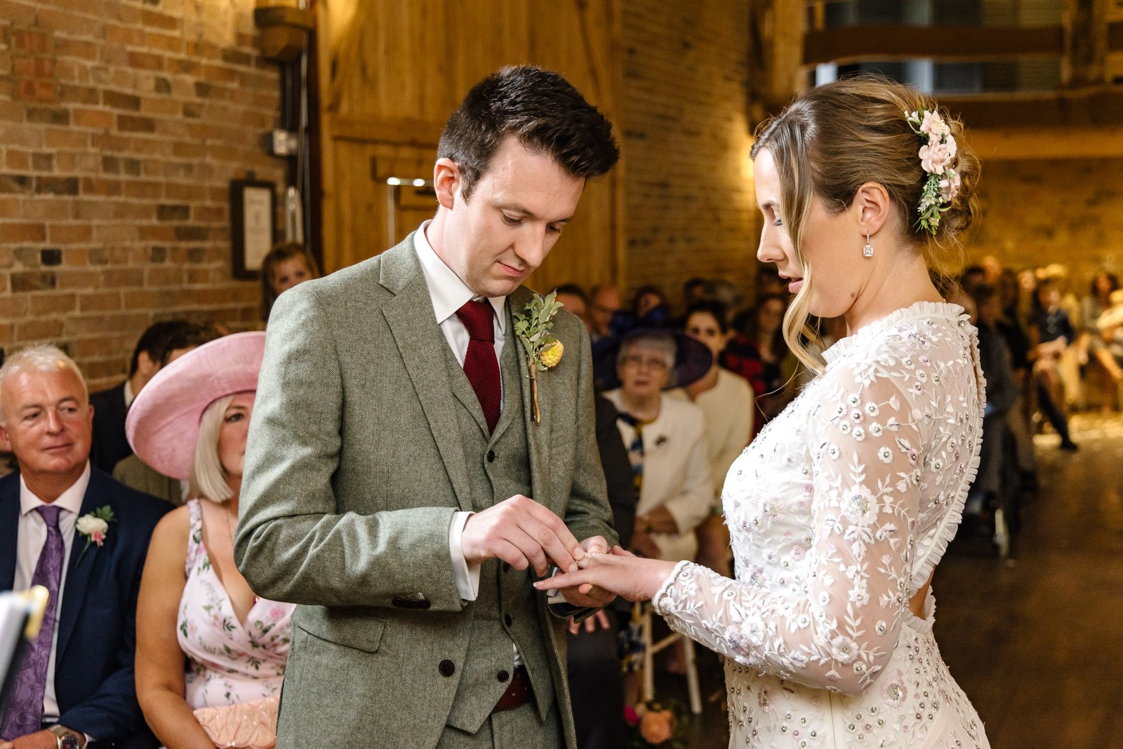 Groom sliding the ring onto the bride's finger during the ceremony