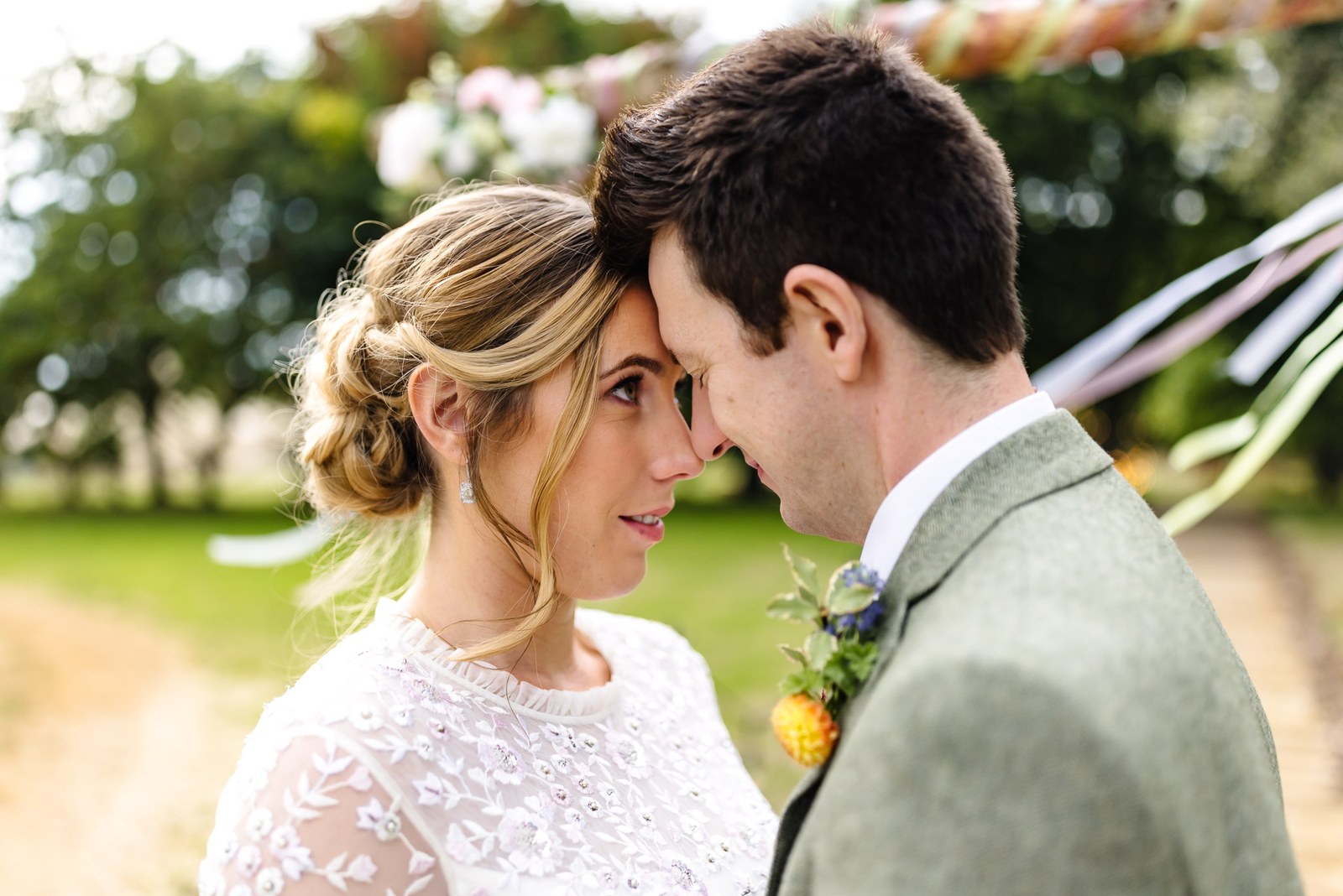Close-up of the couple resting foreheads together, ribbons streaming behind