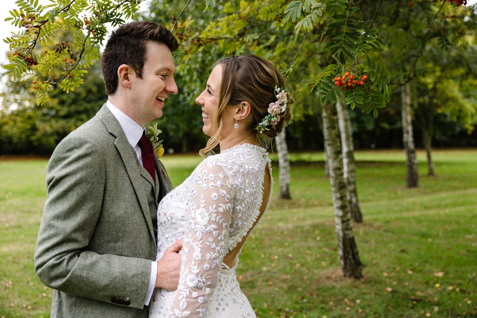 The couple facing each other beneath a berry-laden rowan tree in the Dovecote Events grounds