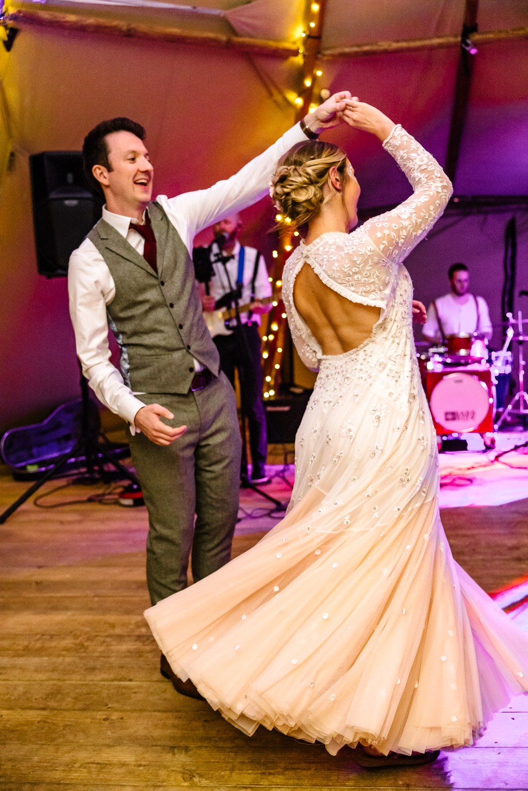 The groom twirling the bride during their first dance as the band plays