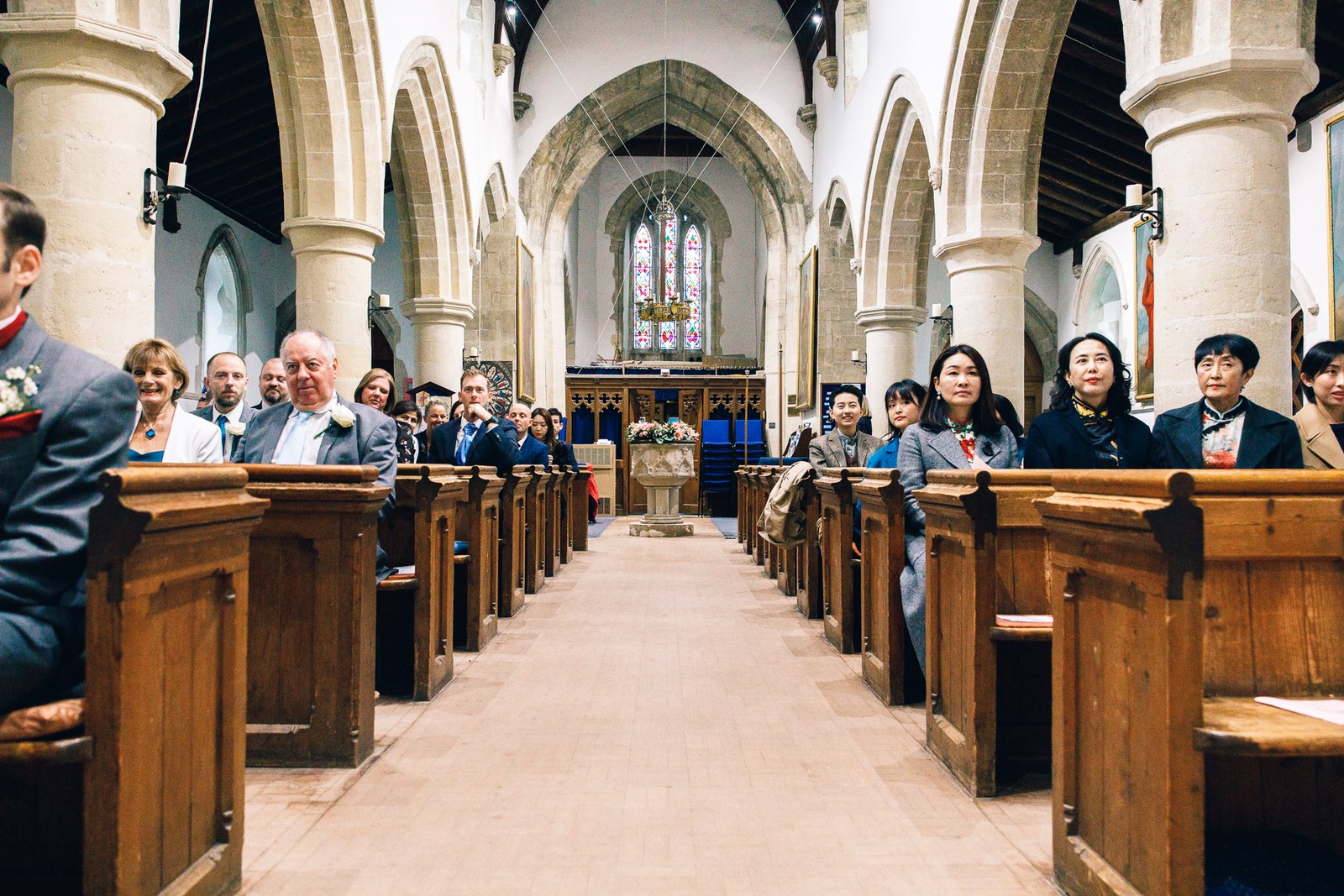 Guests seated in the pews beneath the stone arches of the church nave